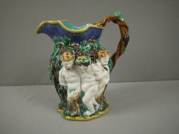 MINTON majolica wine pitcher with mythological fig: MINTON majolica wine pitcher with mythological figures in high relief with grapes and vine on lavender ground, great color and detail, 7", rare form, professional repair to handle
