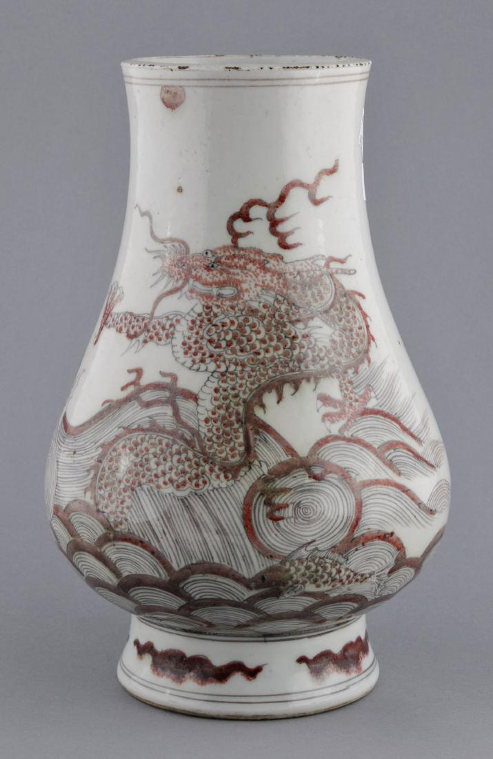 Porcelain vase. China. 19th century. Underglaze red: Porcelain vase. China. 19th century. Underglaze red decoration of a dragon and crashing waves. Six character K'ang Hsi mark on the base. Rim fritting. 11" in height. For additional and high-resolution