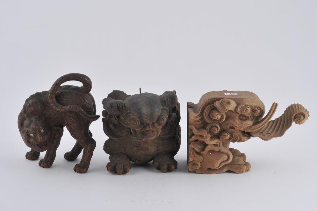 Lot of three wood carvings. Japan. 19th century. A: Lot of three wood carvings. Japan. 19th century. A tiger with inlaid eyes together with two architectural elements: A shishi and an elephant. Each about 4" long. All items in session one were collecte