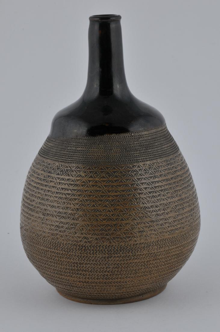 Pottery bottle. Japan. 19th century. Sake tokkuri: Pottery bottle. Japan. 19th century. Sake tokkuri basket pattern body with a purple brown glaze at the mouth and shoulder. 9" h. All items in session one were collected by William H. Smith (1853-1923)