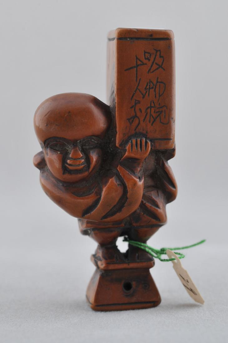 Carved wooden Netsuke. Japan. 19th century. Comic: Carved wooden Netsuke. Japan. 19th century. Comic figure of a baggage handler. Inscriptions on the box. 2". All items in session one were collected by William H. Smith (1853-1923)