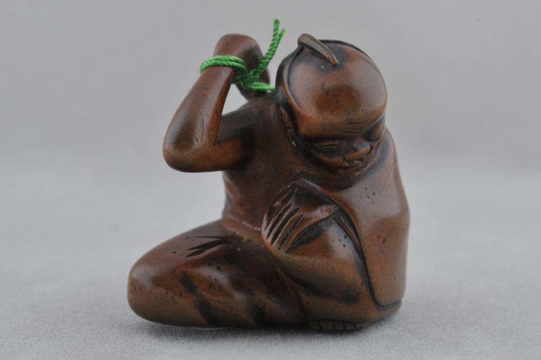 Carved wooden Netsuke. Japan. 19th century. Seated man: Carved wooden Netsuke. Japan. 19th century. Seated man using a back scratcher. 1-1/4". All items in session one were collected by William H. Smith (1853-1923)