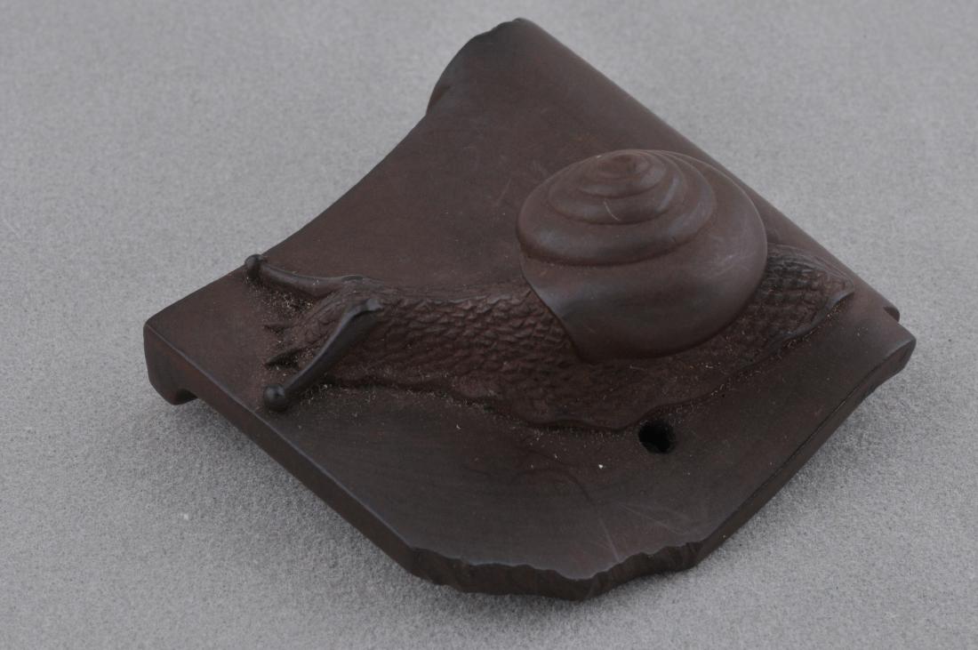 Carved wooden Netsuke. Japan. 19th century. Study of a: Carved wooden Netsuke. Japan. 19th century. Study of a snail on a broken roof tile. 1-1/2". All items in session one were collected by William H. Smith (1853-1923)