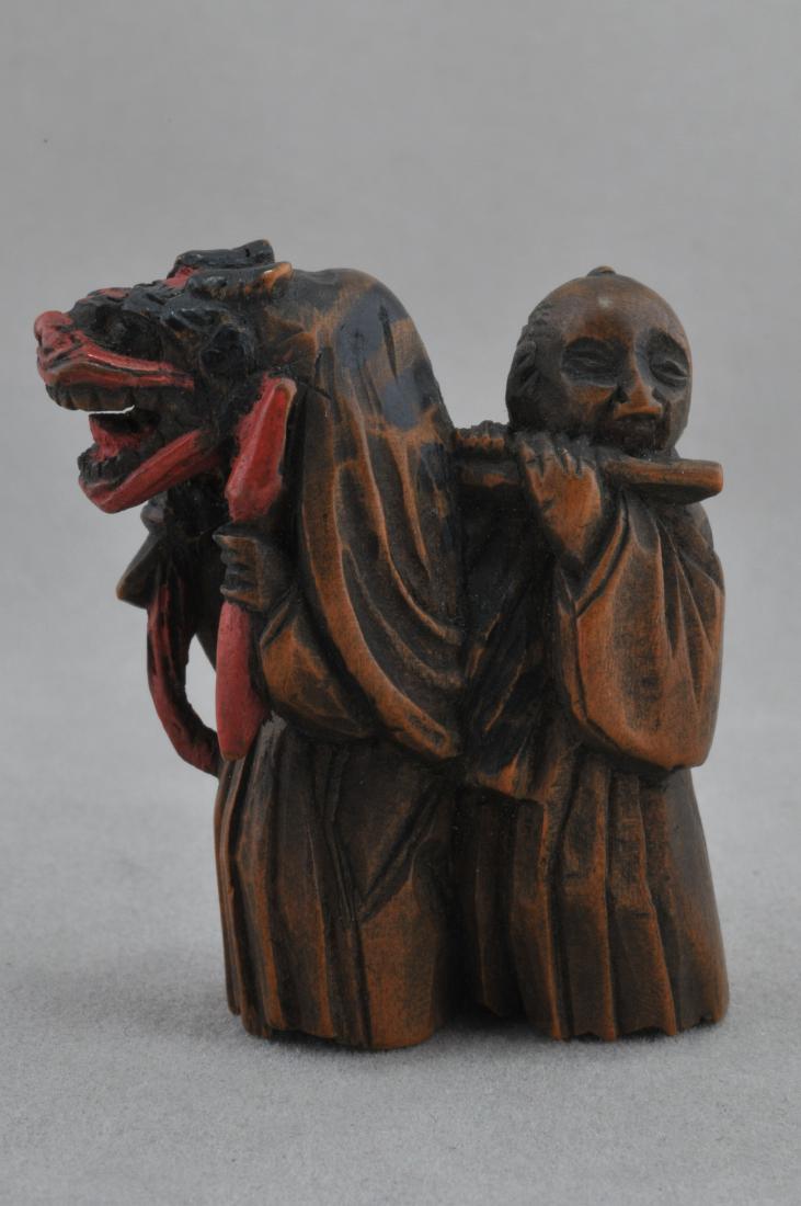 Carved wooden Netsuke. Japan. 19th C. Dancer in Mask.: Carved wooden Netsuke. Japan. 19th century. Dancer in a Shishi mask accompanied by a flutist. Lacquered accents. Signed Kazumasa. 1-1/2". All items in session one were collected by William H. Smith (1