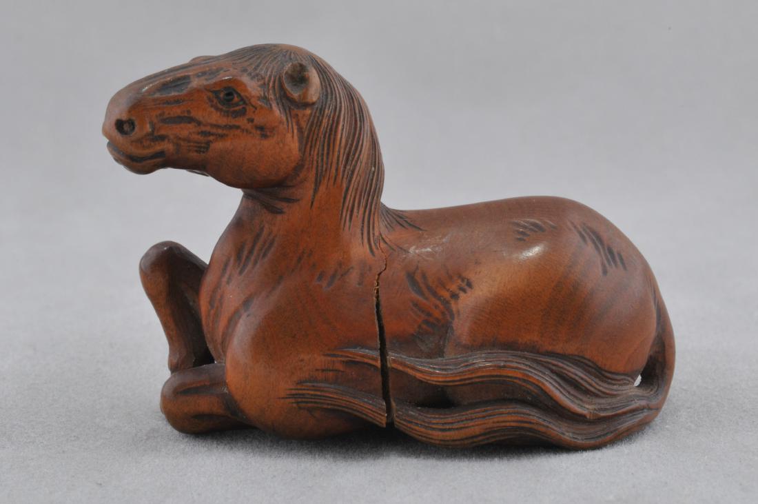 Carved wooden Netsuke. Japan. 19th century. Study of a: Carved wooden Netsuke. Japan. 19th century. Study of a reclining horse. 1-1/2". Crack. All items in session one were collected by William H. Smith (1853-1923)