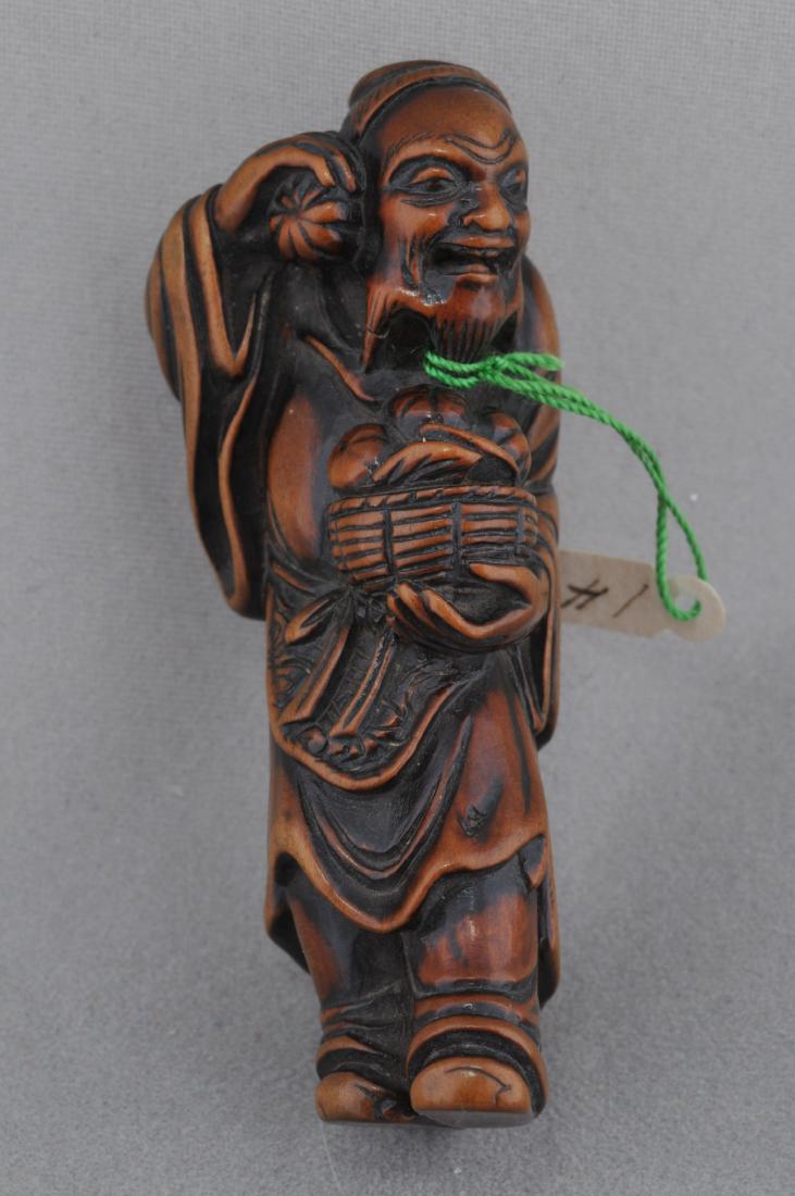 Carved wooden Netsuke. Japan. 18th/19th century.: Carved wooden Netsuke. Japan. 18th/19th century. Standing fiugre of a sennin holding a basket of fruit. 2-1/4". All items in session one were collected by William H. Smith (1853-1923)