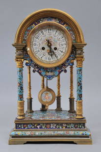 A massive French Champleve mantle clock. The bronze: A massive French Champleve mantle clock. The bronze dore/ormulu/vermeil case having a dome top. Profusely ornamented with repeating patterns of engine turning. The enamel decorated dial having Arabic