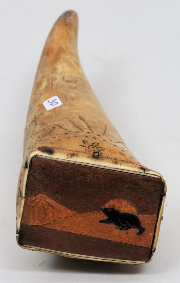A unique Powder Horn measuring 7" long with an inlayed: A unique Powder Horn measuring 7" long with an inlayed wood scene on the butt plug. It appears to be a Wolf with a rising Moon and a Mountain in the background with three different colors of wood used