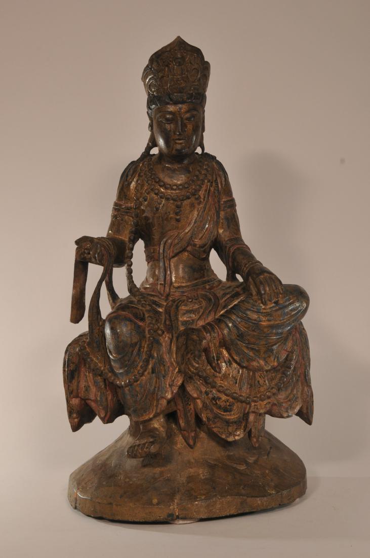 Wood carving. China. 19th century. Seated figure of: Wood carving. China. 19th century. Seated figure of Kuan Yin on a rocky throne. 20" high 11" wide.