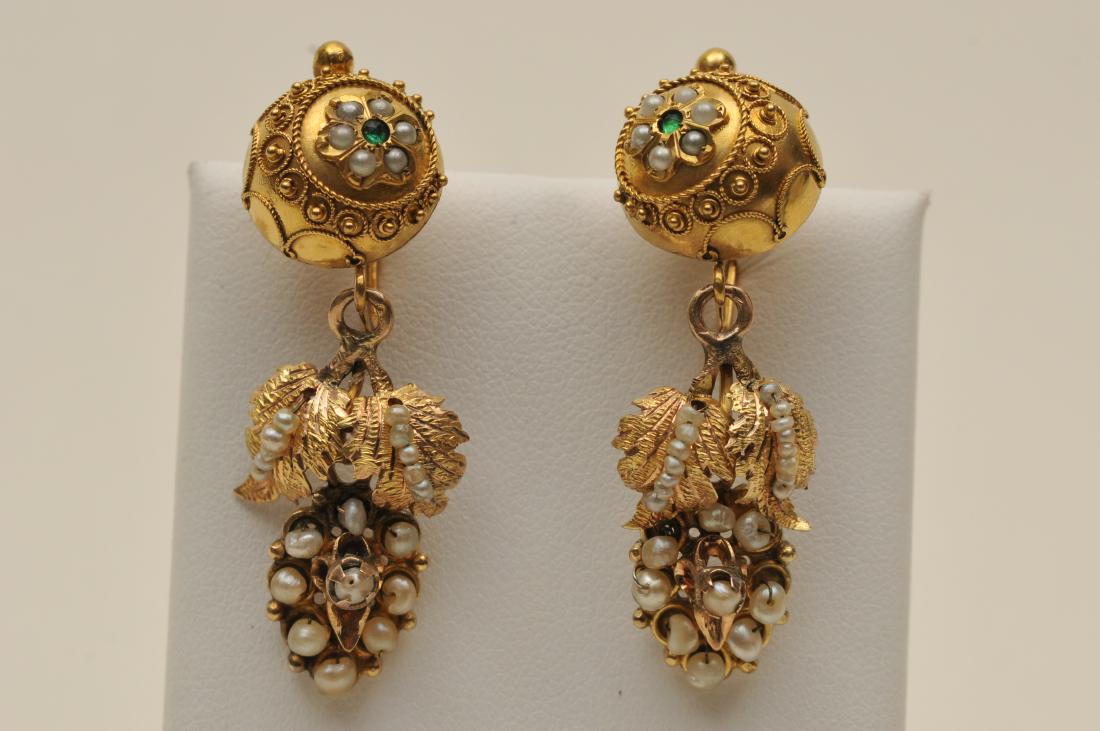14k yellow gold antique grape cluster earrings. Each: 14k yellow gold antique grape cluster earrings. Each earring features an emerald, with various sized seed pearls. Total weight of 8.9g.