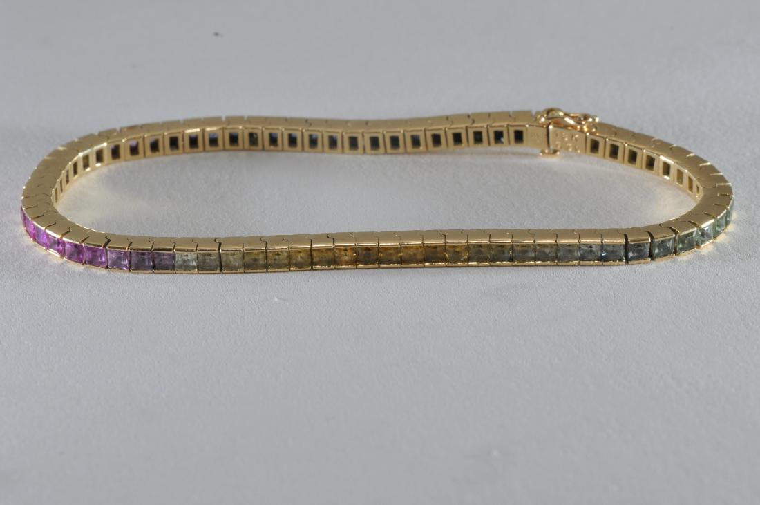 18k yellow gold and sapphire tennis bracelet.: 18k yellow gold and sapphire tennis bracelet. Multicolored "rainbow" square-cut sapphires, each approximately 2.5 x 2.5mm each. Colors include blue, pink, yellow, and light green. Stones are commercia