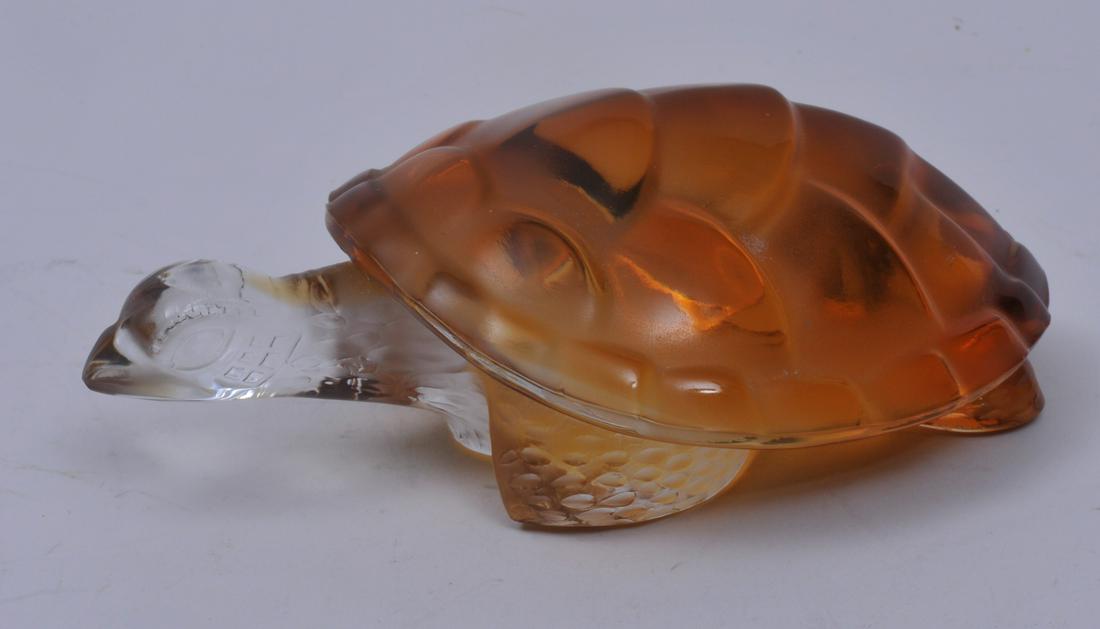Lalique glass amber to clear turtle paperweight. Signed: Lalique glass amber to clear turtle paperweight. Signed on base. Chip on edge of shell. 6" long. 3-3/4" wide. 2-1/4" high.
