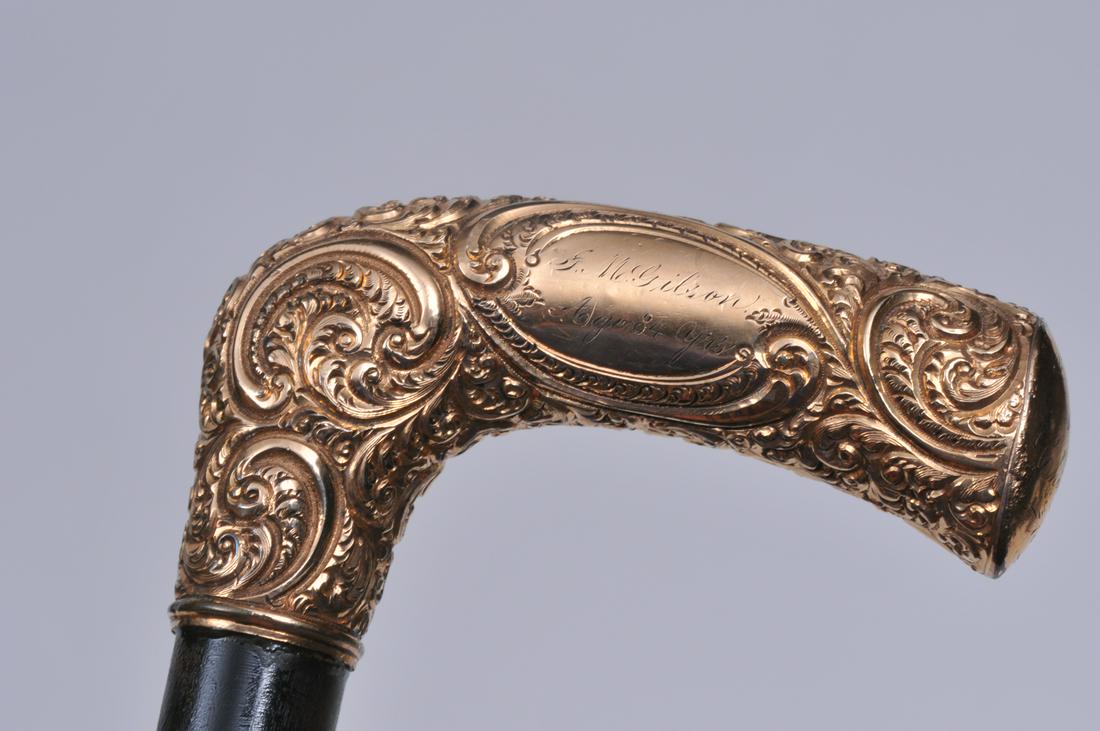 Wood cane with gold plated handle. Engraved on side of: Wood cane with gold plated handle. Engraved on side of handle- "G.M. Gibson. Age 84 years. From his children 1889". No makers marks found. 33-1/2" long. Handle is 4" x 1".
