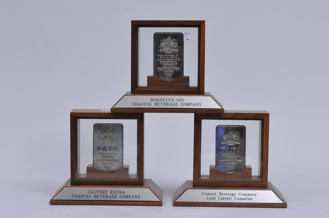 Three Tiffany & Co. sterling silver presentation ingots: Three Tiffany & Co. sterling silver presentation ingots mounted and framed. "Beverage Companies". Papa Perennial Annual Performance Award 1987". Calvert Extra-Burnett's Gin-Coastal Beverage-Lord Calve