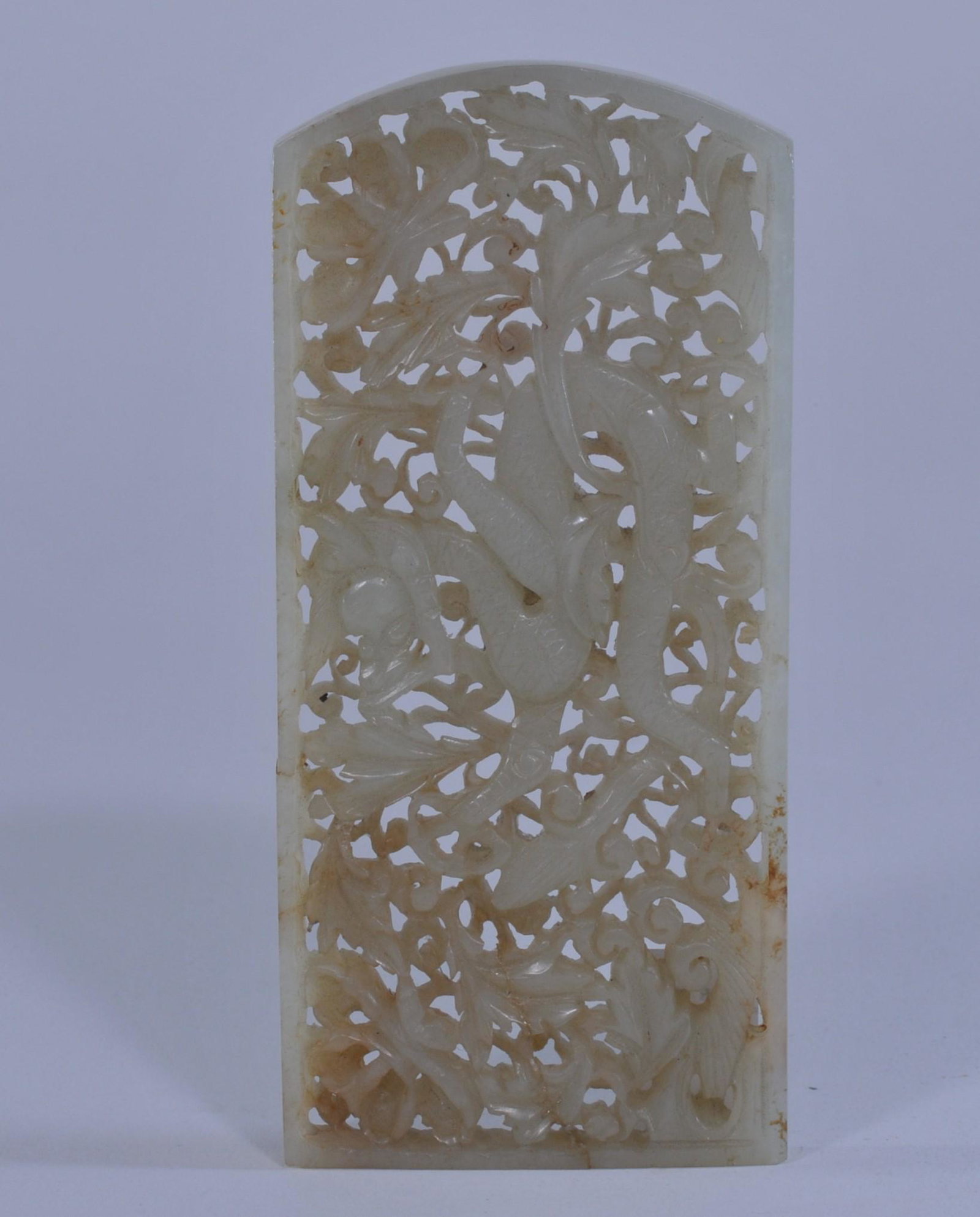 Jade belt plaque. China. Ming period. (1368-1644). Pale: Jade belt plaque. China. Ming period. (1368-1644). Pale celadon stone carved and pierced with a dragon and foliage. 4-1/2" x 2-1/8". Repaired, and with loss. Damage visible from rear side.