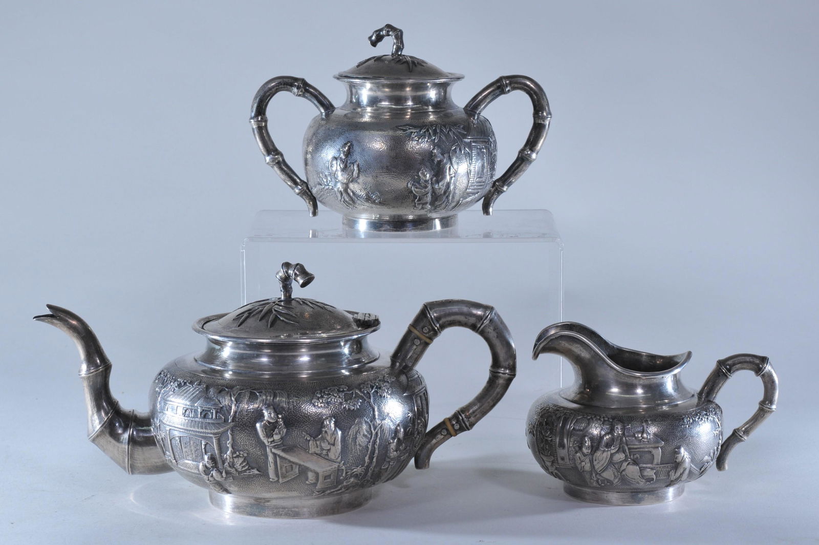 Silver tea set. Chinese Export. Early 20th C. Repousse: Silver tea set. Chinese Export. Early 20th C. Repousse work of figures in landscapes on a punched roe ground. Marked silver 90. 37.8 ozt.