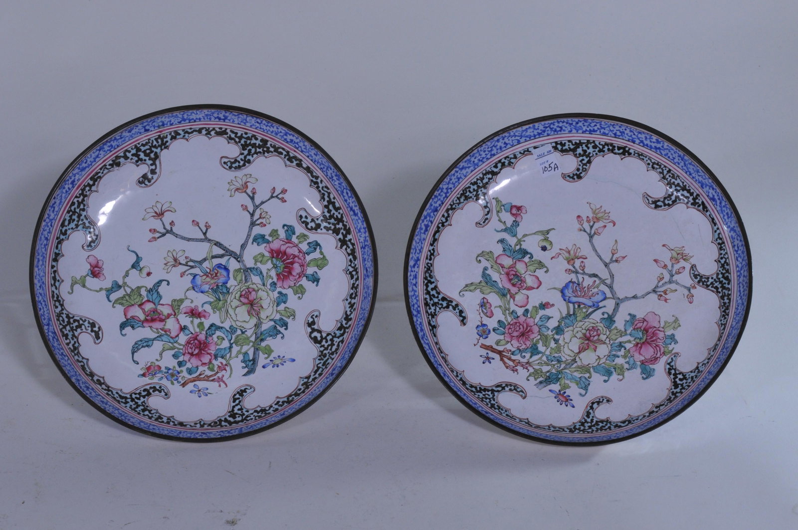 Pair of Canton enameled plates. China. 19th C.: Pair of Canton enameled plates. China. 19th C. Decoration of flowers. Peaches on the base. 8-1/4"D. Rim frits. Hairline cracks to one.