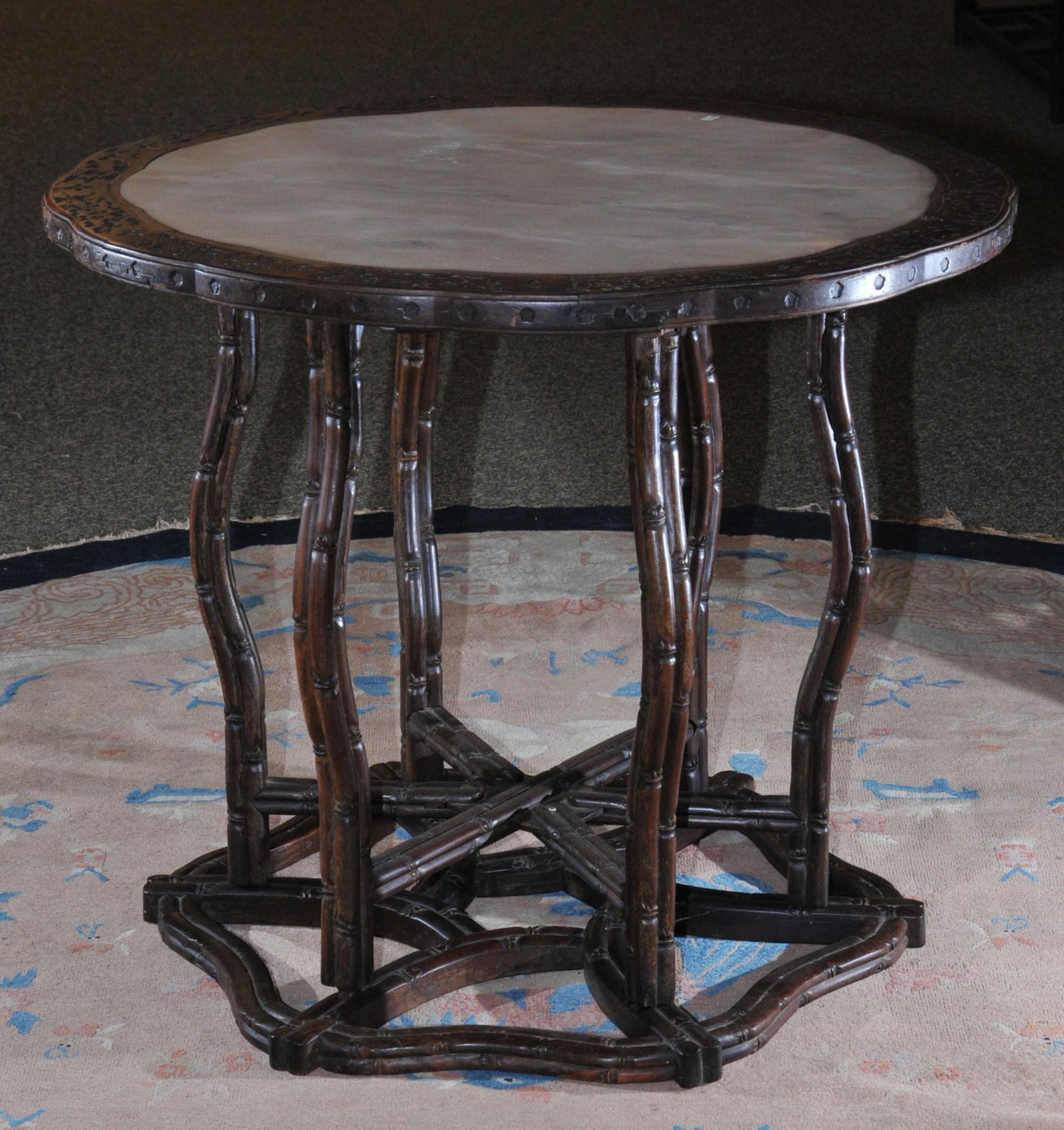 Occasional table. China. 19th C. Rosewood. Top inset: Occasional table. China. 19th C. Rosewood. Top inset with a marble t op. 34" d. 27" h. Two part folding base. Chip to wood top.
