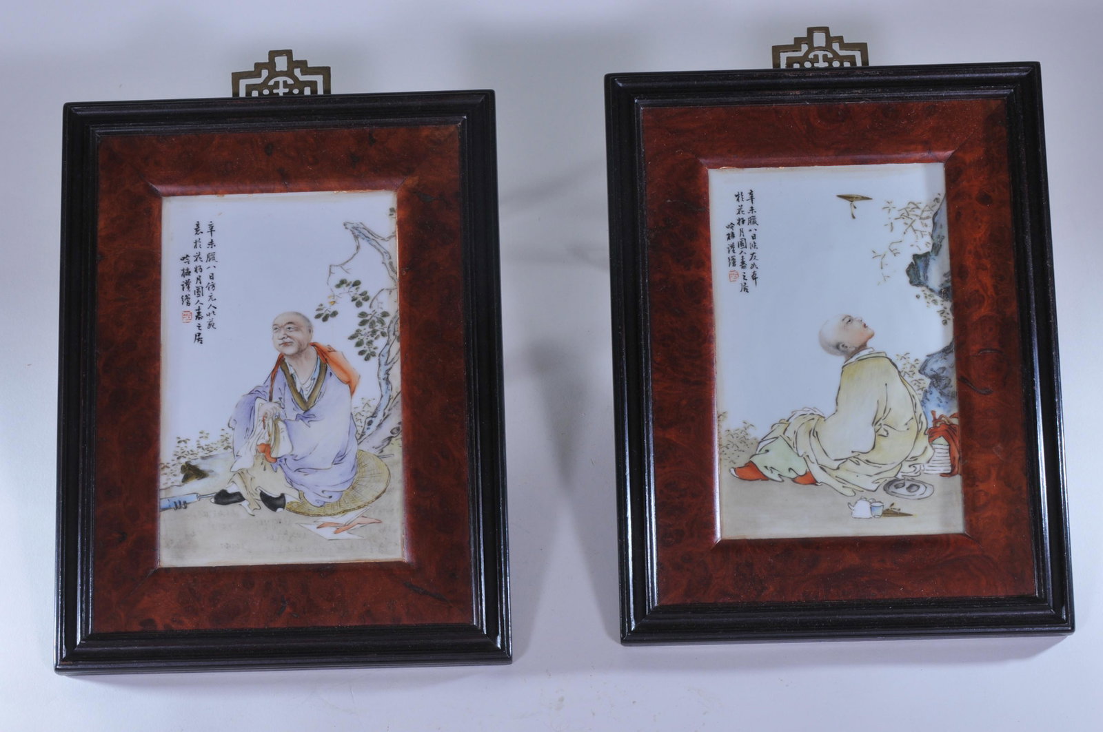 Pair of porcelain plaques. China. Republic period. Fen: Pair of porcelain plaques. China. Republic period. Fen Tsai decoration of Buddhist saints with inscription. Rosewood and burlwood frames. 7" x 5-1/4" sight size without frames.