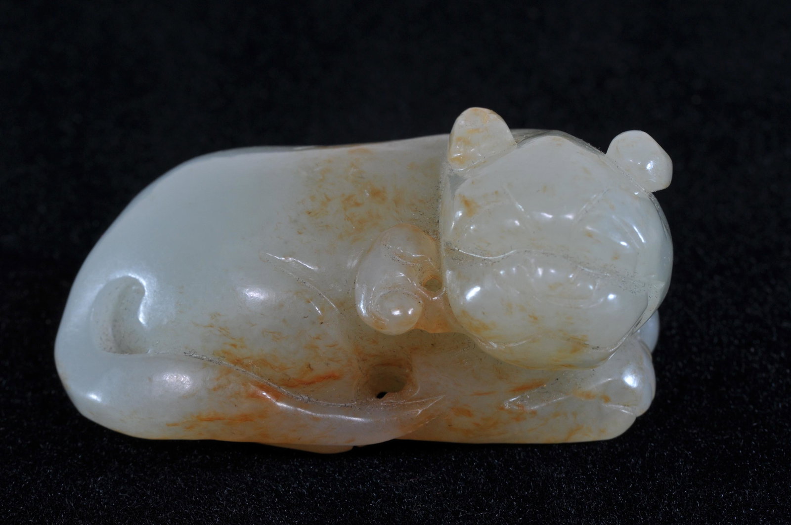 Jade carving. China. 19th C. Stone of greenish white: Jade carving. China. 19th C. Stone of greenish white with russet markings. Mythical animal with ling Chih in its mouth. 2-1/4" long