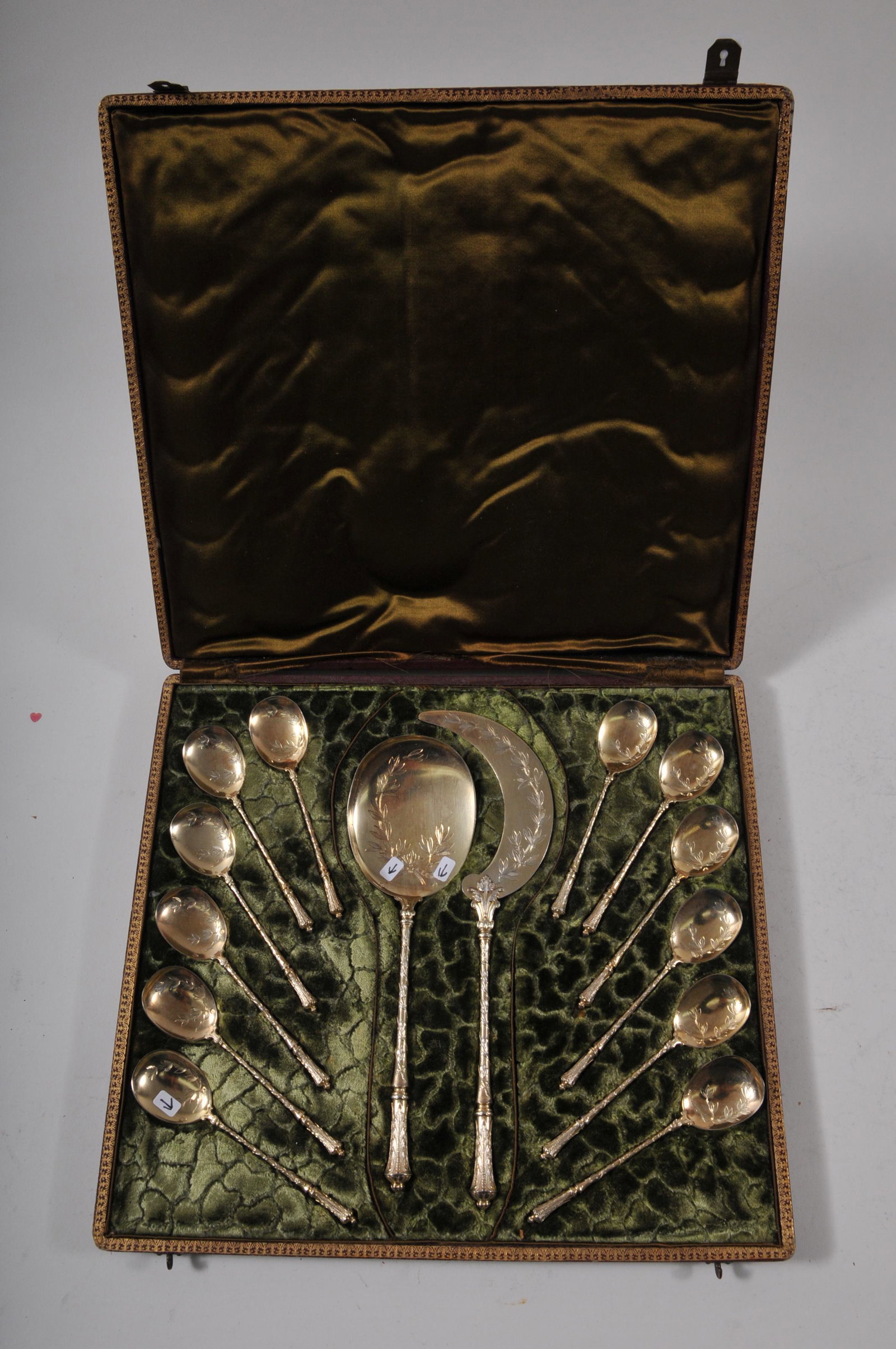 19th century French sterling silver fourteen piece: 19th century French sterling silver fourteen piece cased gilt Ice Cream set. Large sickle form blade cutter- 10-1/4" long. Large serving spoon. Twelve Ice Cream spoons. Floral vine decorated stems. Et