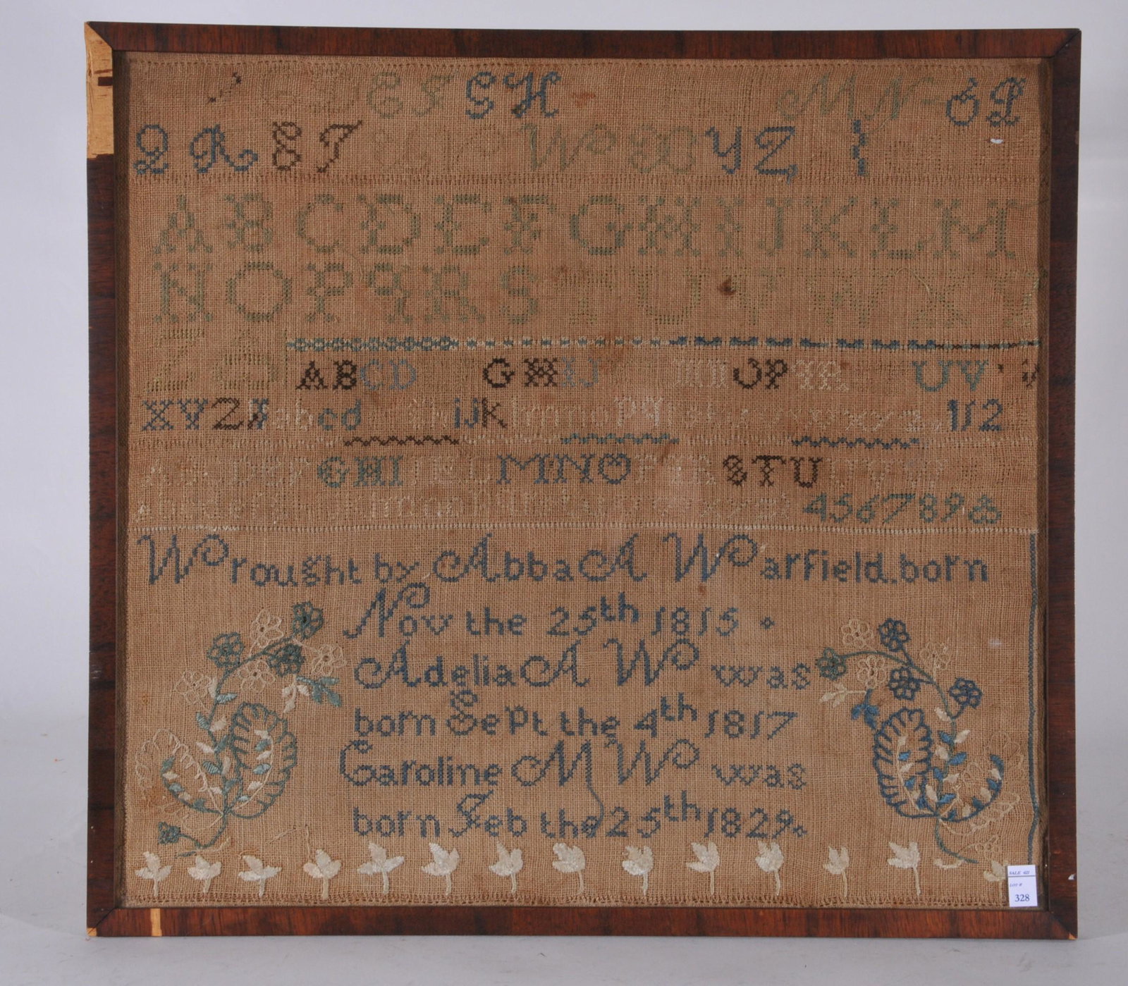 American Framed sampler linen and cotton stitching. By: American Framed sampler linen and cotton stitching. By Abba A. Warfiled, born Nov. the 25th 1815. Detailed with alphabet and floral decoration. Framed and glazed, staining and fading. Sight size 15 ¾