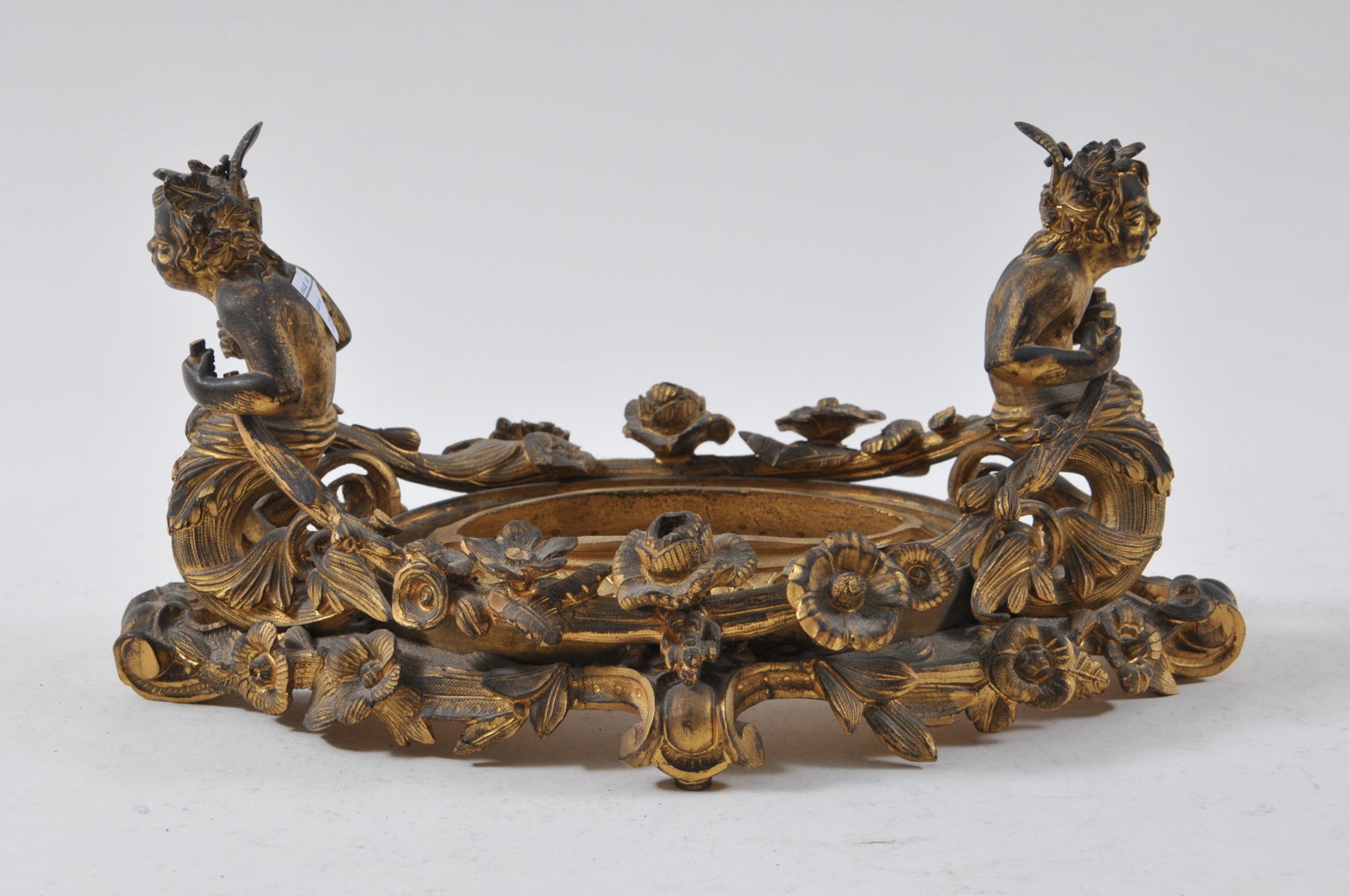 19th Century ormolu vase stand with figural handles and: 19th Century ormolu vase stand with figural handles and floral garlands. Length 12” Width 5 ½”