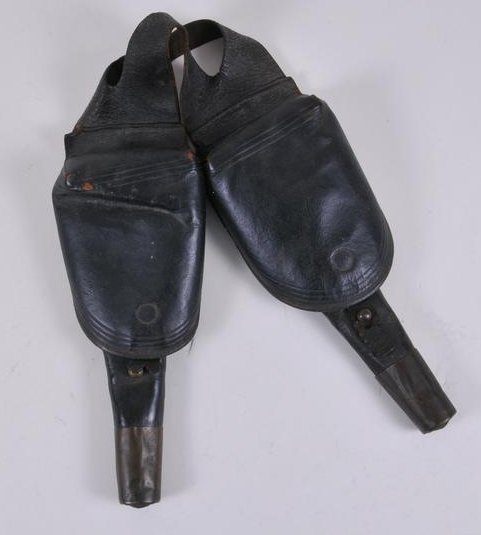 Early Saddle Pommel Holsters with Embossed Stars on the: Early Saddle Pommel Holsters with Embossed Stars on the bottom of the brass end caps. 12" holsters are connected with a double leather yoke, both holsters with Black leather flaps, likely 1850s era. T