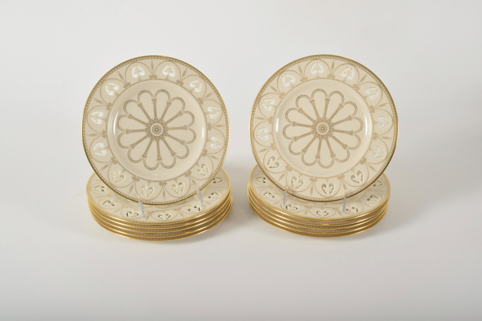 Lenox "Modano Lace" Luncheon Plates: Lenox â€œModano Lace” Luncheon Plates. Pierced heart design along rim with gilt columns and floral motifs. 12 plates. 9 ¼” diameter.
