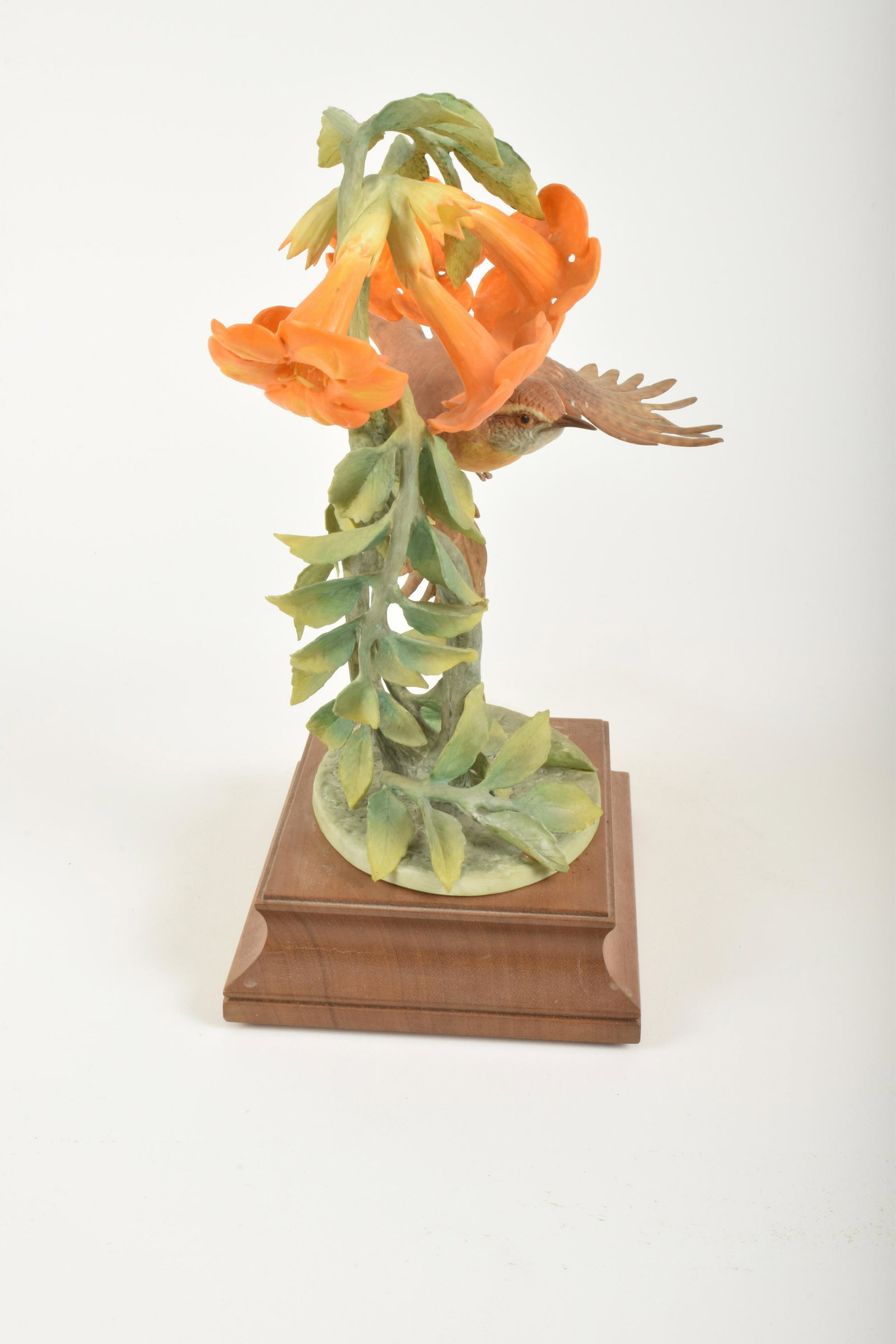 Royal Worcester Bone China "Carolina Wren and Trumpet: Royal Worcester. Bone China "Carolina Wren and Trumpet Creeper," made in England circa 1977. Approximately 10.5" high and 7.5" at widest point. Includes wooden base. No box. Break to one leaf (include