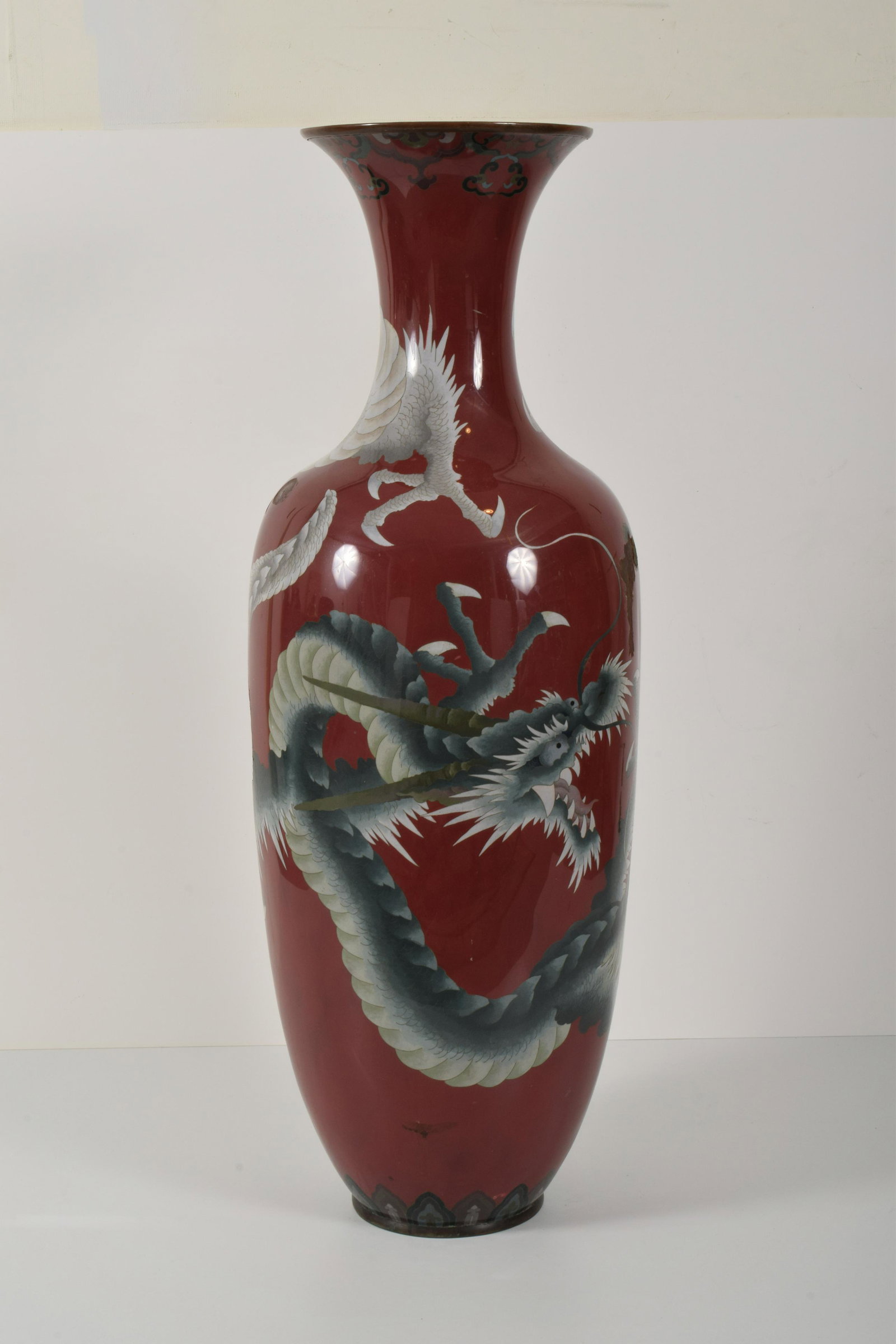 Japanese Meiji Period Cloisonne Temple Vase: Cloisonne temple vase. Japan. Meiji period (1868-1912). Red ground with a grey dragon. 46"H. Impact marks and areas of surface loss, no base. Areas of dents and enamel loss. From the estate of Frank G