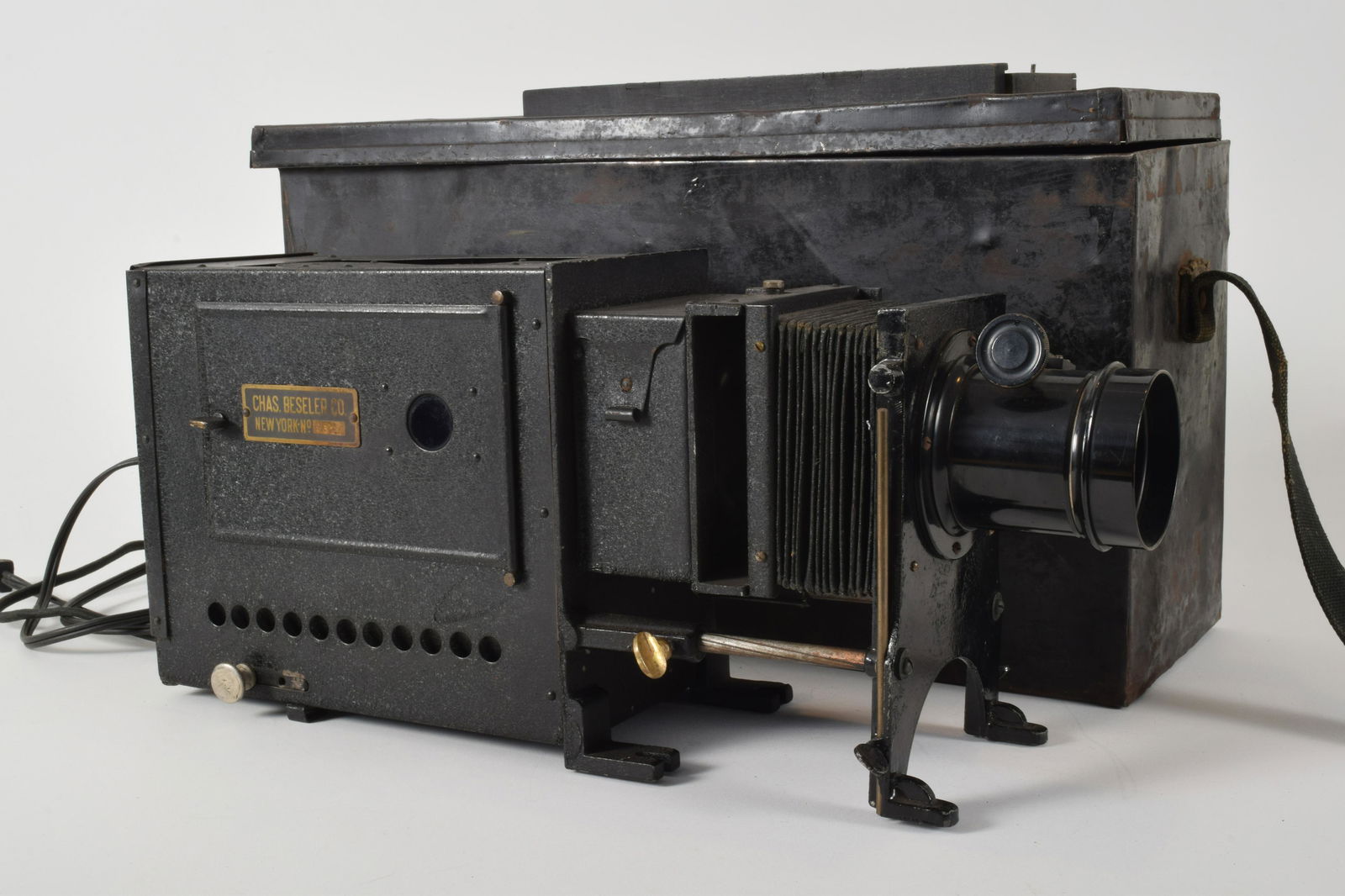 Charles Beseler Cased Lantern Projector: Cased lantern projector, Charles Beseler, New York. No. 9513. Surface rusting to case, other wear consistent with age and use, untested. 11” x 22” x 7”.