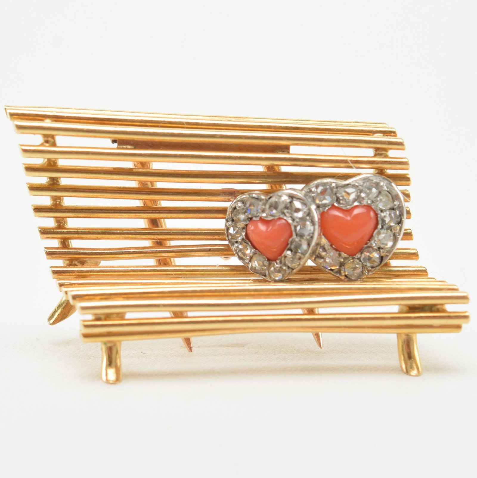 Cartier 18K Gold "Lovers on a Bench" Brooch: Cartier ‘Lovers on a Bench’ brooch. 18k yellow gold, platinum, coral, and diamonds. Overall size 29 x 17mm. Two heart-shaped red corals surrounded by 20 rose-cut diamonds in a platinum set