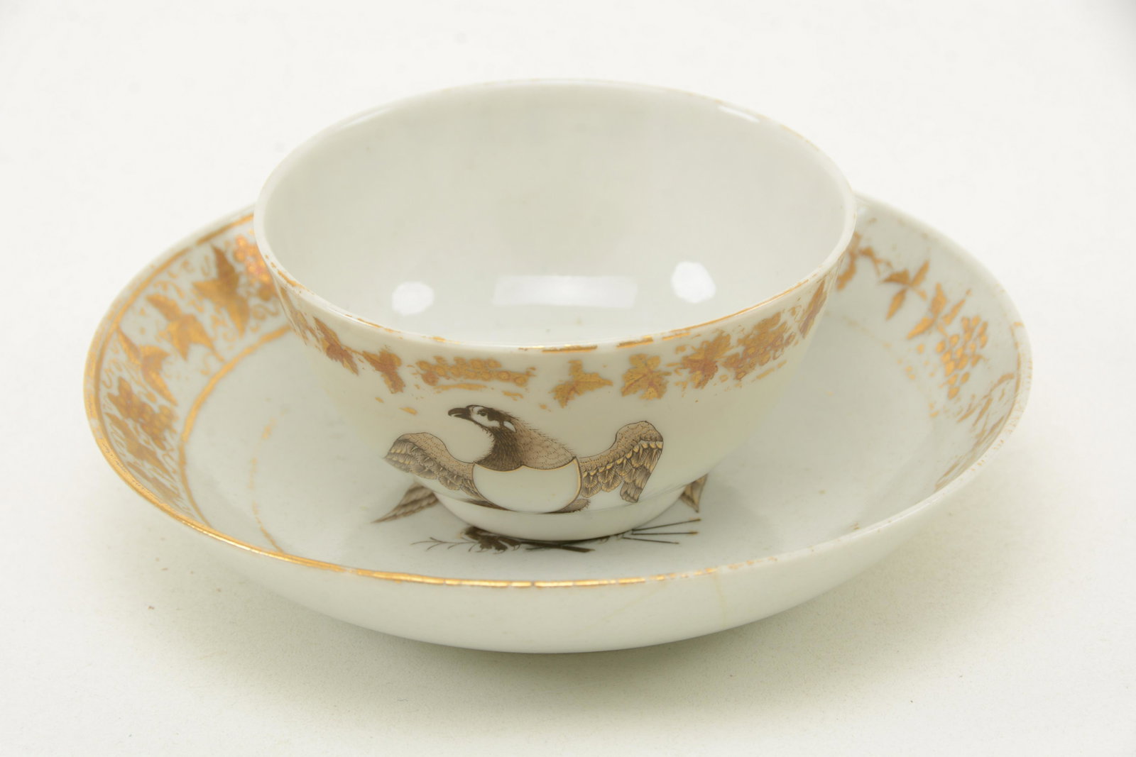 Chinese Export porcelain cup and saucer with American: Chinese Export porcelain cup and saucer with American Eagle decoration, circa 1800. Mottahedeh collection, with gilt border. 5.5 saucer diameter 3.5” cup diameter. Loss to gilding and graphics F
