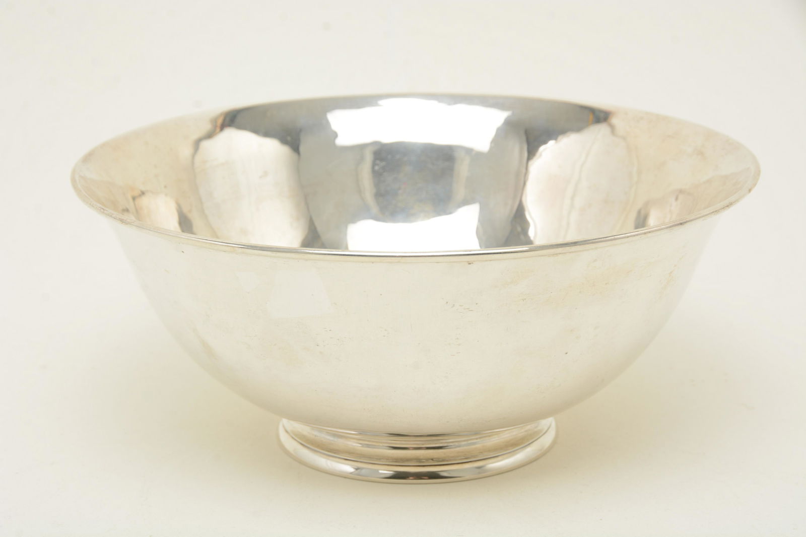 Arthur Stone sterling silver footed punch bowl. Flared: Arthur Stone sterling silver footed punch bowl. Flared rim. Mark to underside. Height 4”. Width 9.5”. Weight 23.29 ozt. Scratches and abrasions to basin surface. From the David Thomas Coll