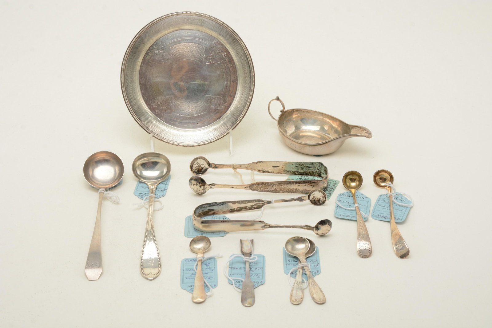 19th Century silver tableware and utensils. Includes a: 19th Century silver tableware and utensils. Includes a sauce boat, possibly by Z. Brigden, pair of salt spoons marked M&W, sugar tongs by Newell Harding and unmarked, etched English plate by Richard M