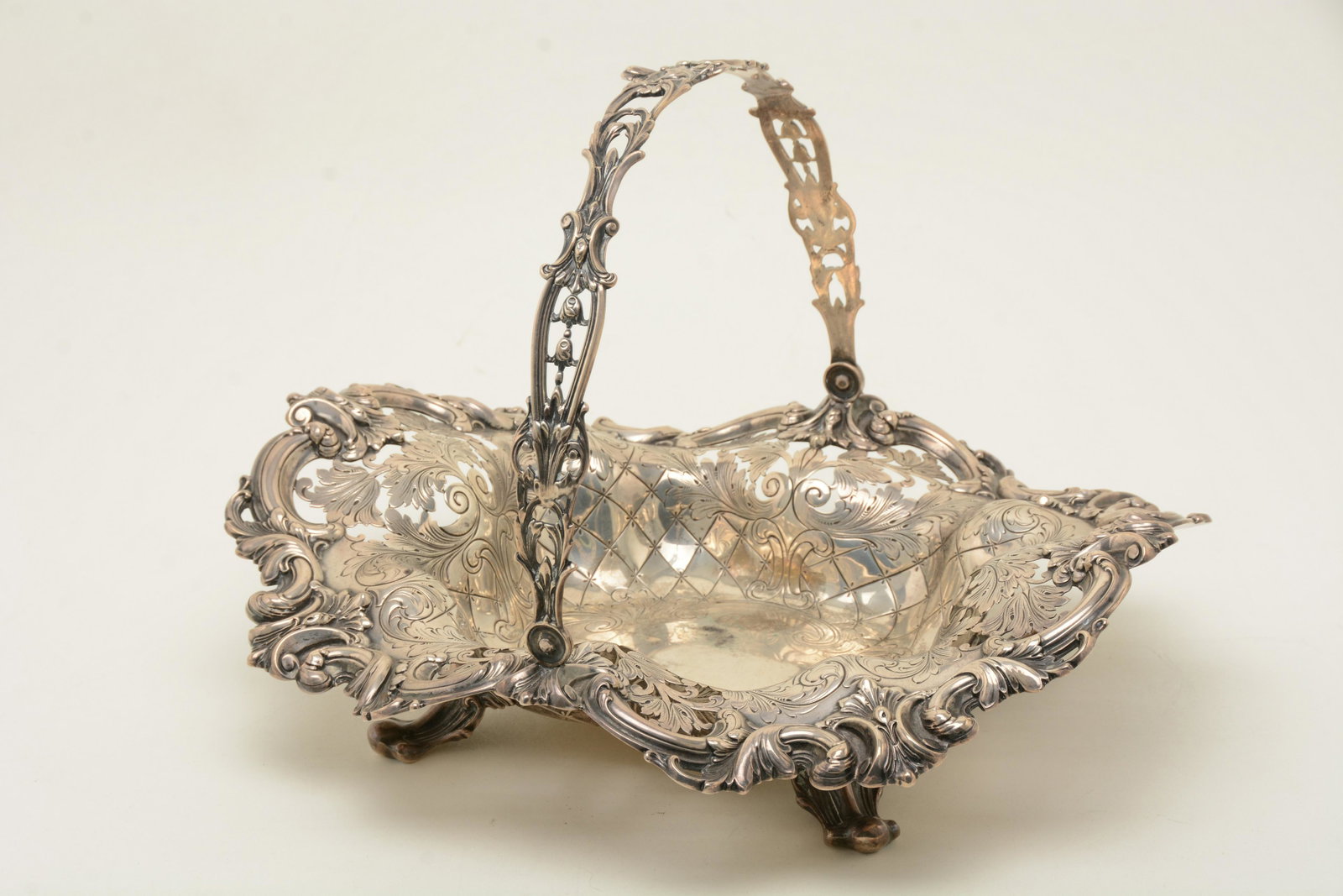 Frank Smith sterling silver large ornate pierced: Frank Smith sterling silver large ornate pierced decorated handled basket with quilted floral decoration. Large scroll feet. Monogrammed. 14-3/4” long. 51.5 ozt. Handle bent slightly.