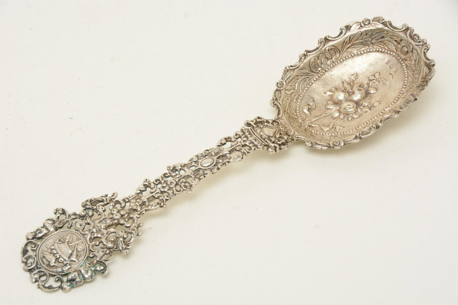Large continental .800 silver ornate pierced decorated: Large continental .800 silver ornate pierced decorated serving spoon. Cherubs, fruit and floral decoration. Hallmarked on bowl. Monogrammed. 10.25” length. 4.6 ozt. Good condition.