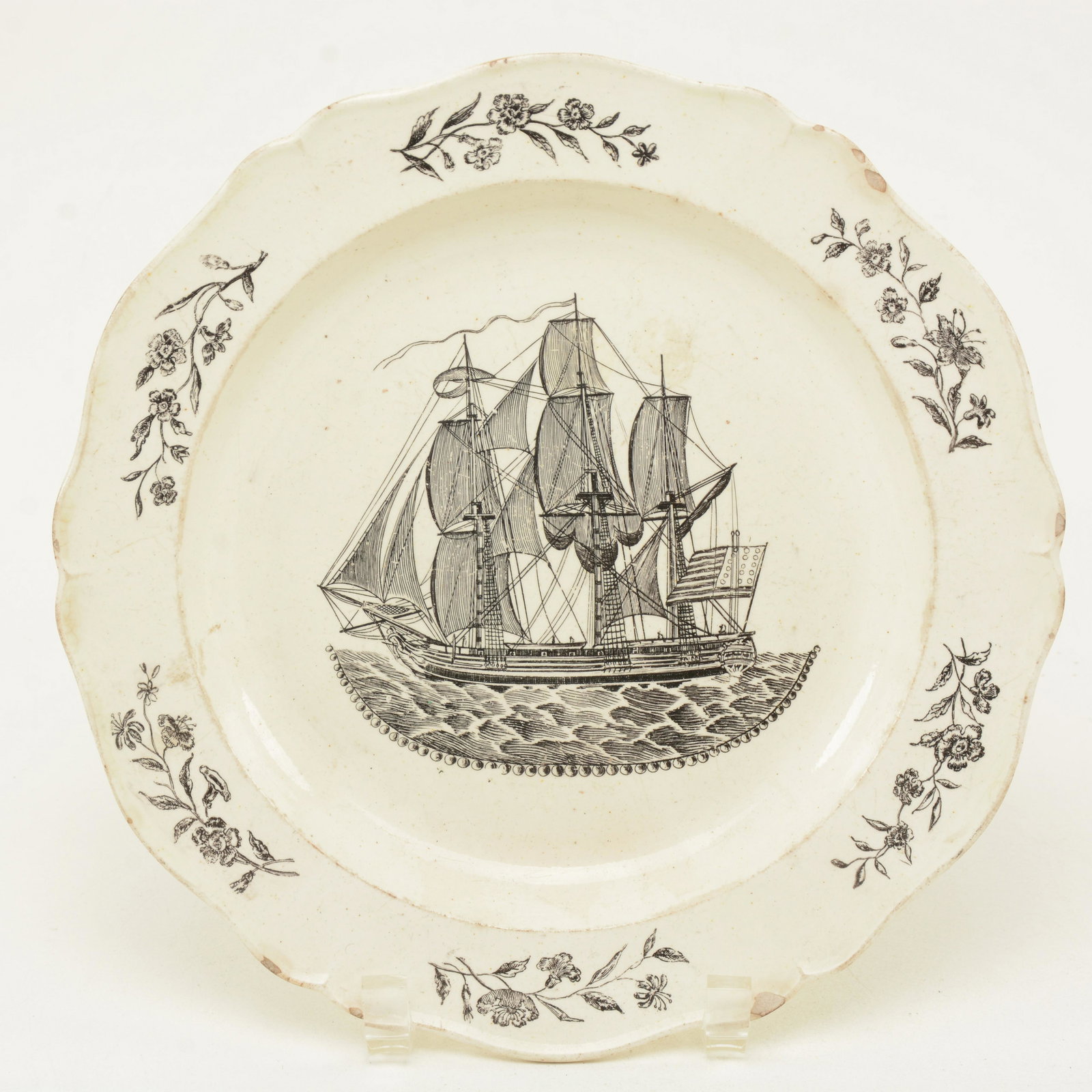 Liverpool American patriotic transfer decorated plate: Liverpool American patriotic transfer decorated plate marked Herculaneum, circa 1800. Image of sailing ship with an American flag. Shaped edge with floral border. 10” diameter. Chips at rim and