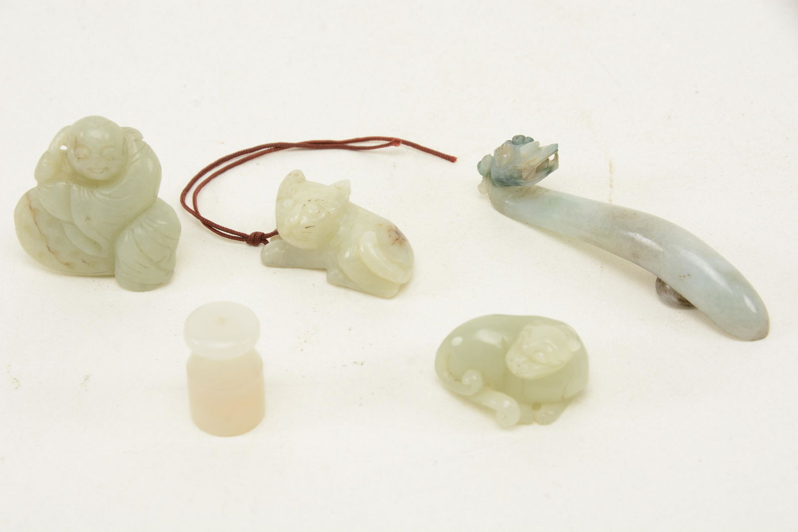 [5] Chinese Qing dynasty carved jade and jadeite: [5] Chinese Qing dynasty carved jade and jadeite pieces. 1) Small white cat with brown highlights. 1.5 in long. 2) Carved green and white jadeite belt buckle with dragon head. 3.375 in long. 3) White
