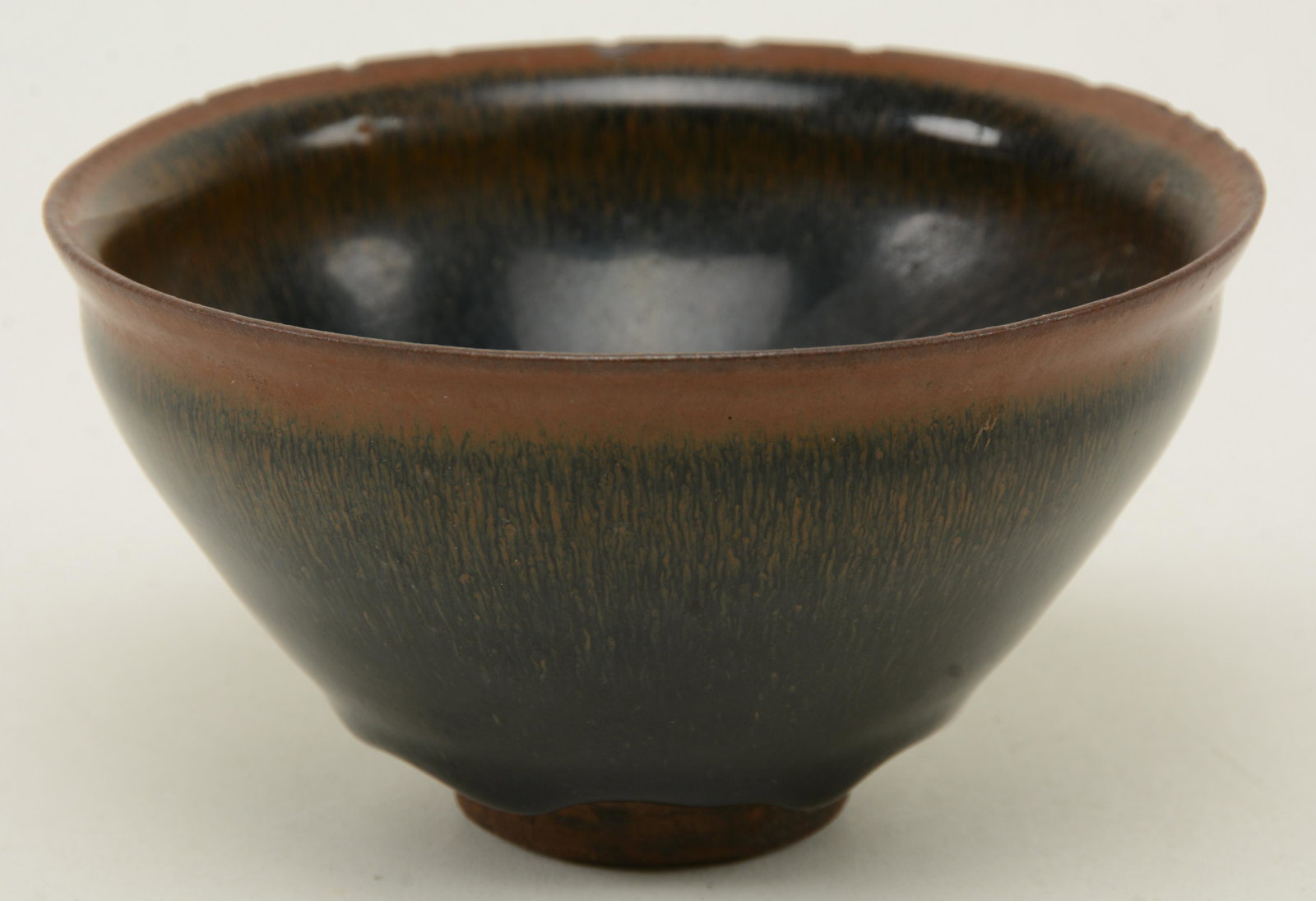 Stoneware Tea Bowl. China. 13th-14th century. Ch’ien: Stoneware Tea Bowl. China. 13th-14th century. Ch’ien ware. Conical form with a hares fur glaze. Rim chips, crack, wear to interior. 5-1/4 in x 3 in.