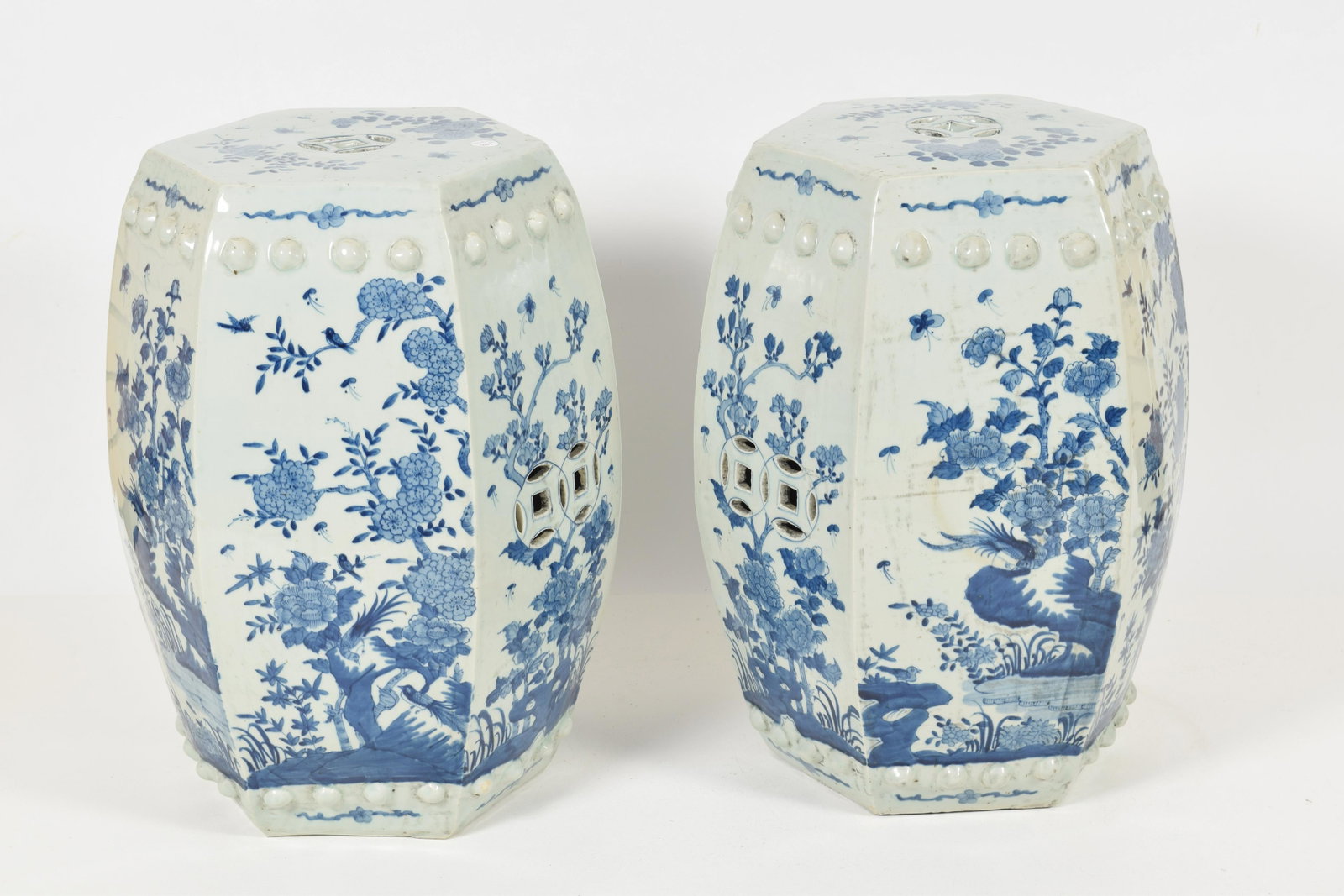 Pair of Hexagonal Blue & White Garden Stools, China,: Pair of Hexagonal Blue & White Garden Stools, China, Republic, each panel decorated seasonal sprays of flowers and with openwork double coin handles.Height 20 in.