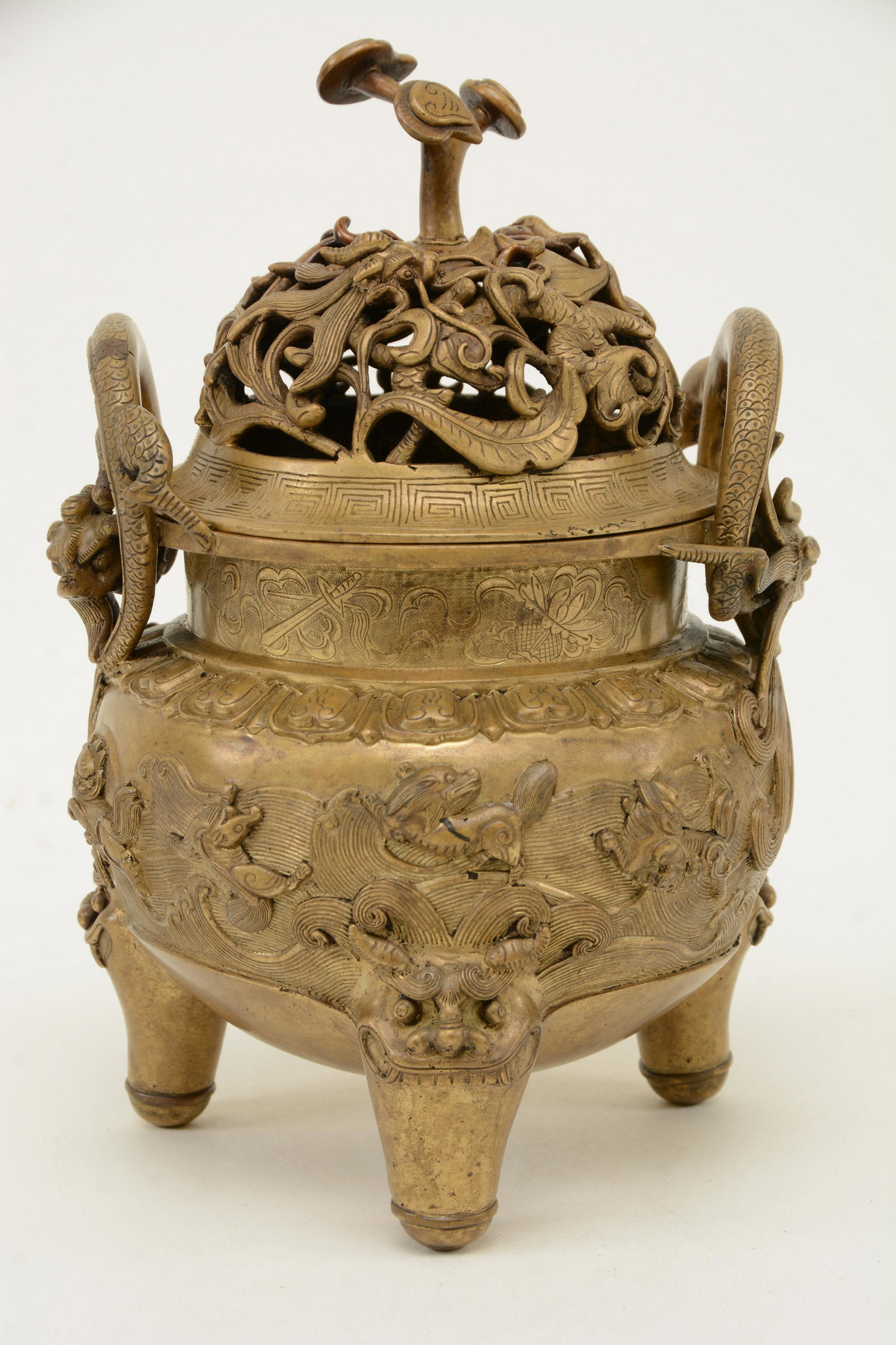 Bronze censer. China. Early 20th century. Decoration of: Bronze censer. China. Early 20th century. Decoration of mythical animals on a wave strewn ground. Dragon handles and cover. Foo dog mask feet. Ju-I finial. Hsuan te mark. 10-3/4 in x 6-1/2 in.