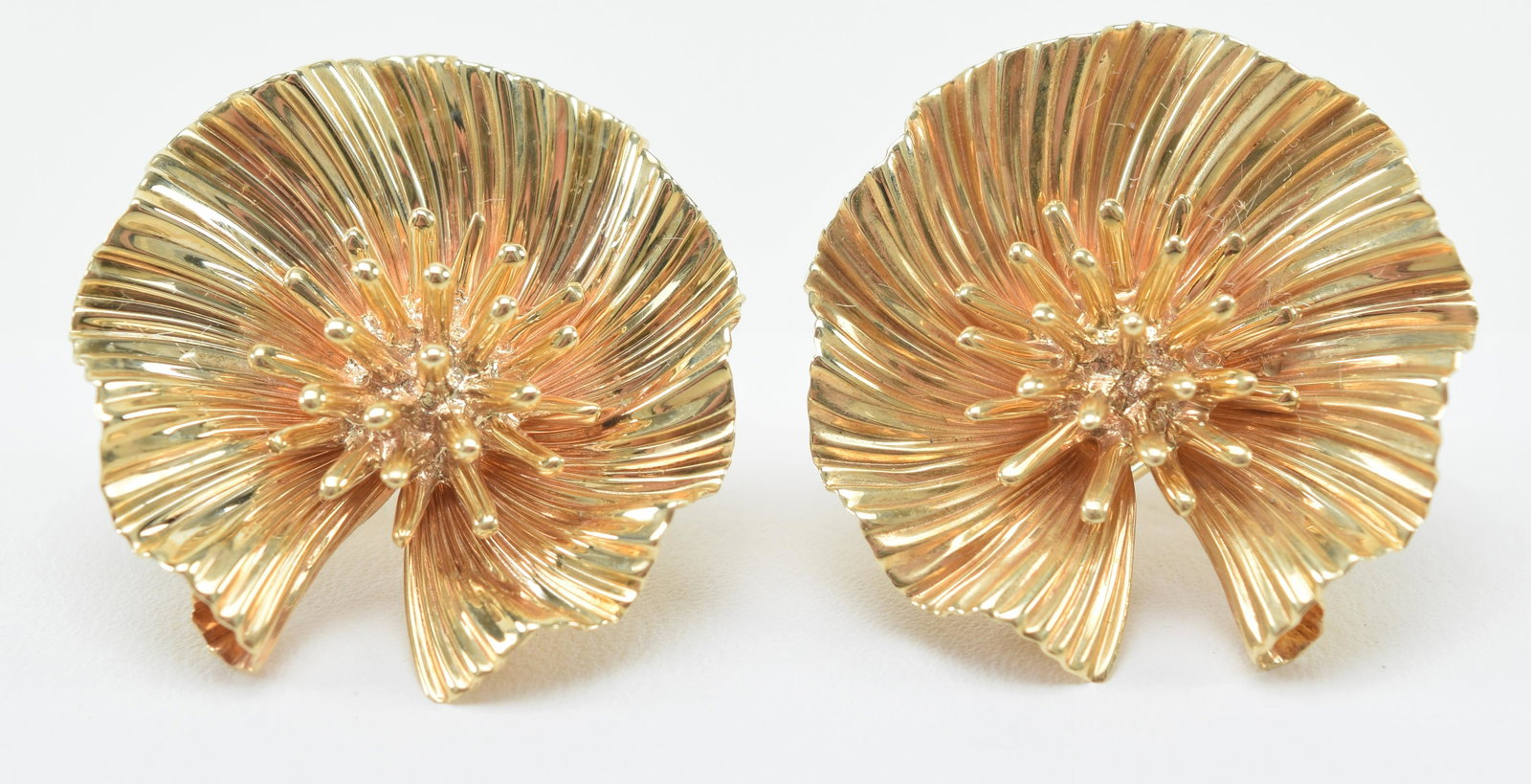 18 kt gold flower form earrings. Omega closures.: 18 kt gold flower form earrings. Omega closures. Unmarked. 7/8in wide. 10.1 grams. Retailed by Firestone and Parson. Boston.