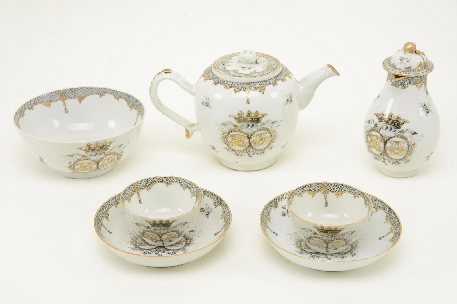 18th Century Chinese export porcelain tea service, some: 18th Century Chinese export porcelain tea service, some early 19th Century. To include: a teapot, milk jug, waste bowl and 2 cups and saucers. Grisaille decoration of crest and cross-hatched borders.