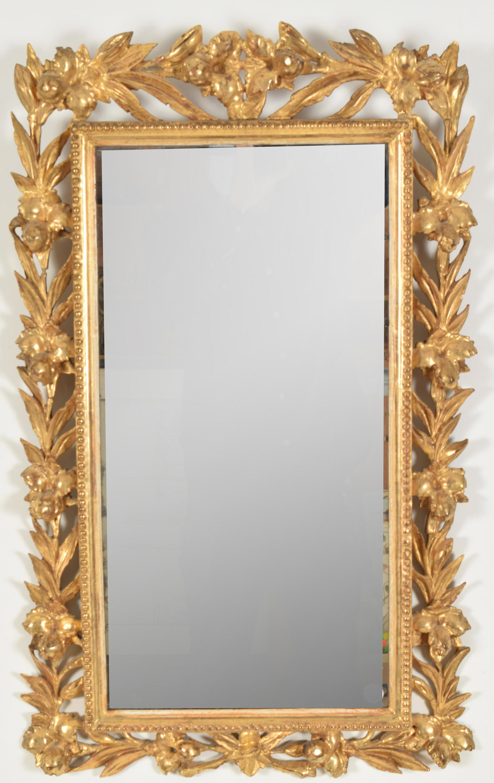 Antique floral gilt carved mirror. Openwork leaf and: Antique floral gilt carved mirror. Openwork leaf and berry border. 28 in x 17 in.