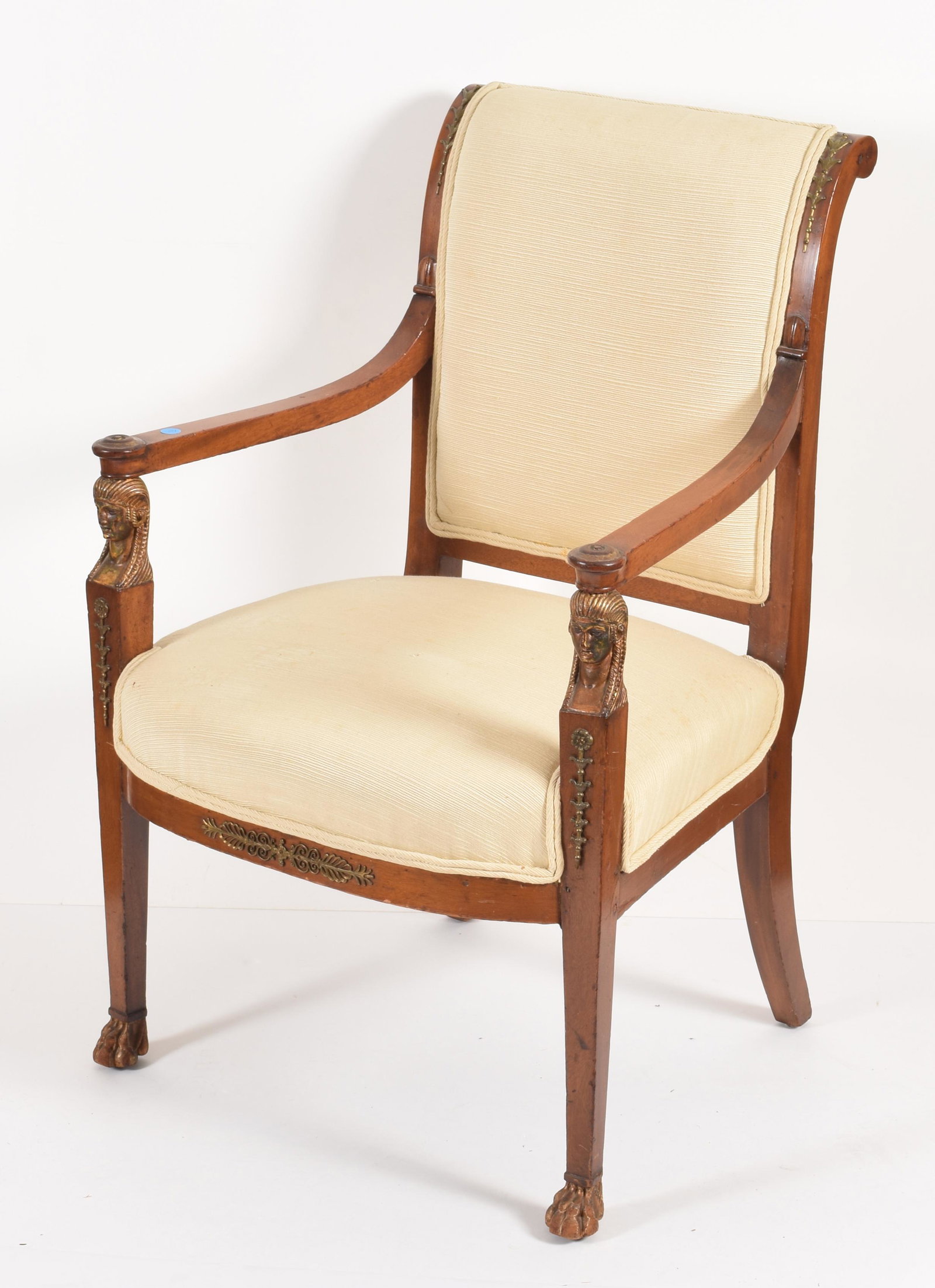 Regency mahogany Egyptian revival armchair, circa 1830.: Regency mahogany Egyptian revival armchair, circa 1830. Ormolu mounts on stiles and skirt. The arm supports finely carved with gilt Egyptian heads on paw front feet and saber rear legs. Height 36in Wi