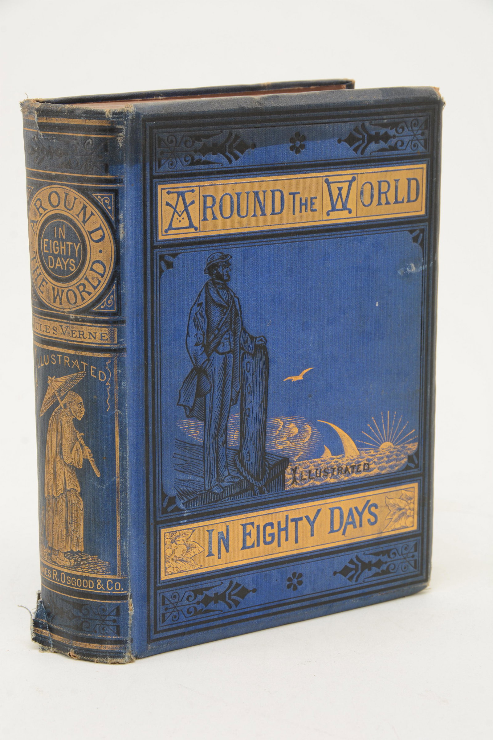 Around the World in Eighty Days by Jules Verne.: Around the World in Eighty Days by Jules Verne. Illustrated. Boston: James R. Osgood & Co., 1874. Embossed blue cloth boards with gilt decoration. Wear at corners, damage to top and bottom of spine. B