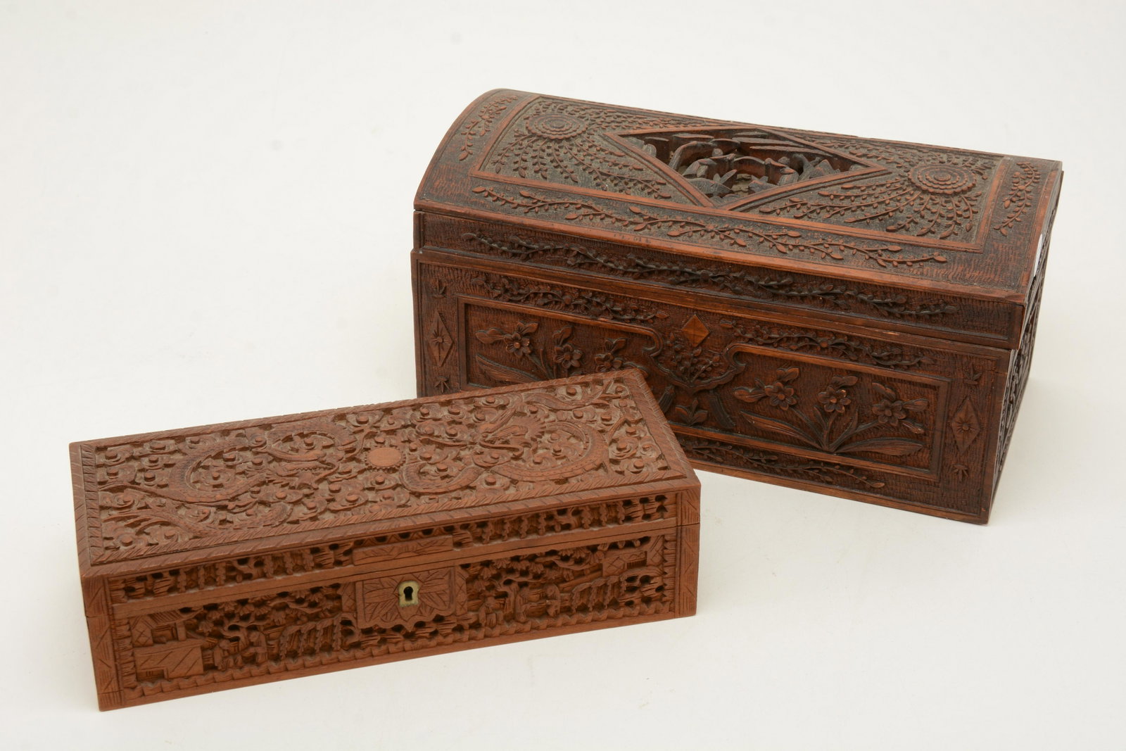 Chinese carved sandal wood boxes. One with carved: Chinese carved sandal wood boxes. One with carved dragon top and figural scenes, the other with floral scenes and pierced scene in rhombus cartouche to top. 11.25 in width of largest.