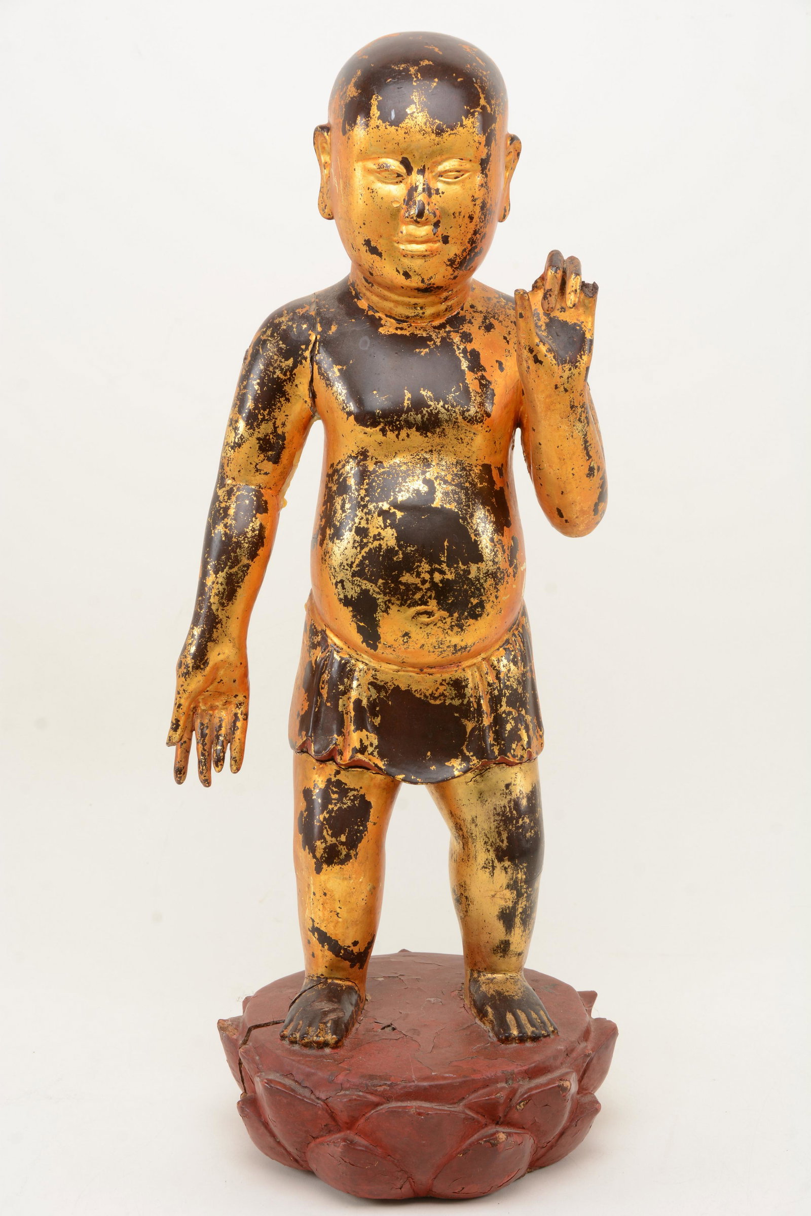 Chinese gilt wood carved figure standing on red lotus: Chinese gilt wood carved figure standing on red lotus flower base. 20.5 in height. Minor chips and wear to base.